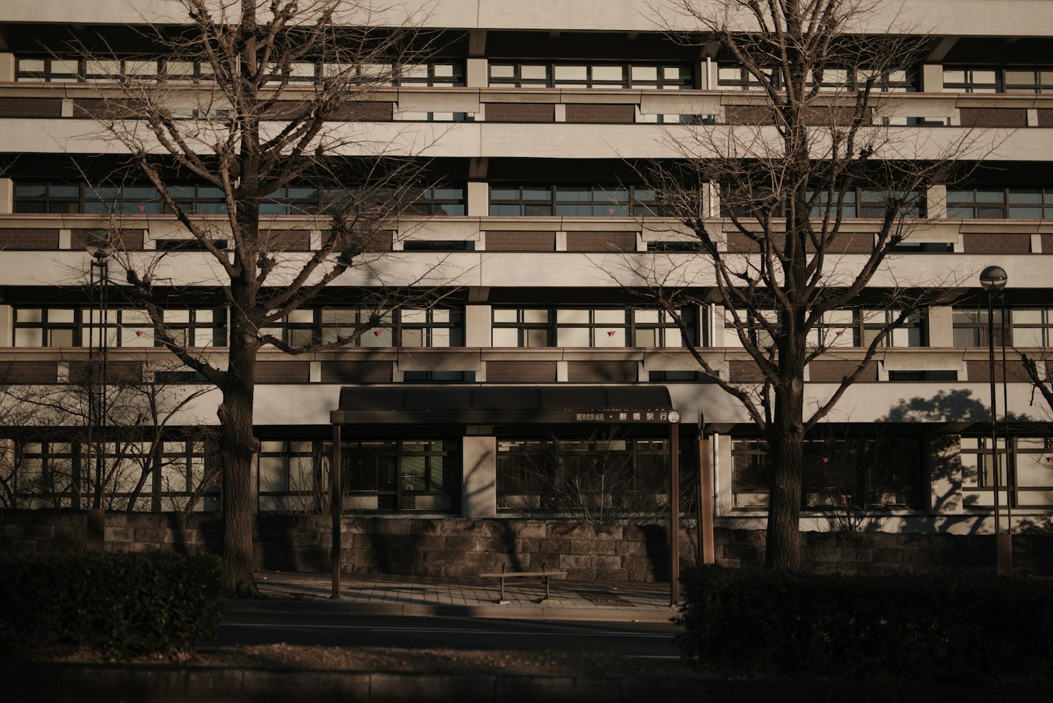 Facciata di un grande edificio in cemento con alberi circostanti