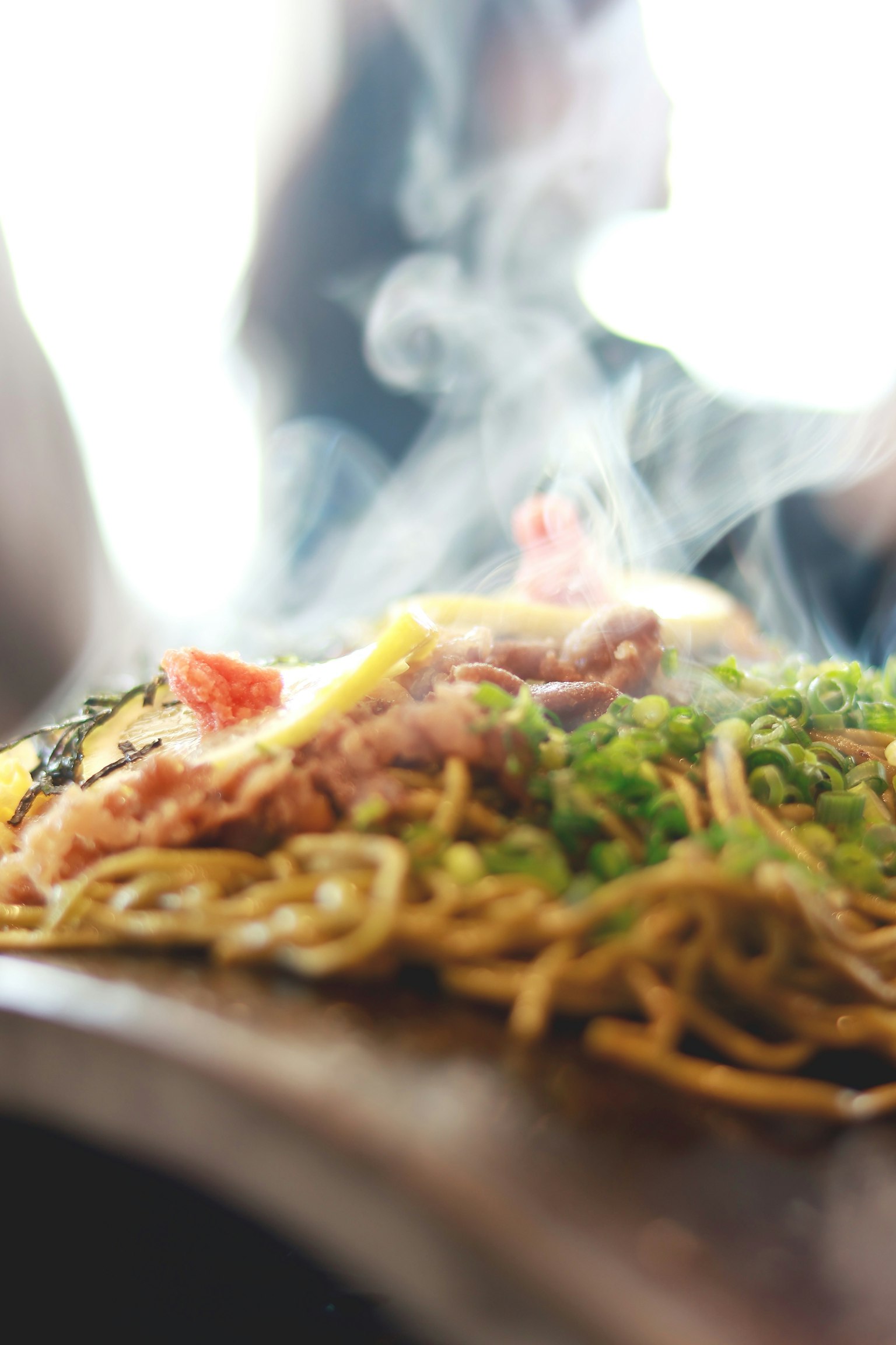 Đĩa mì xào nghi ngút khói với hành lá và thịt