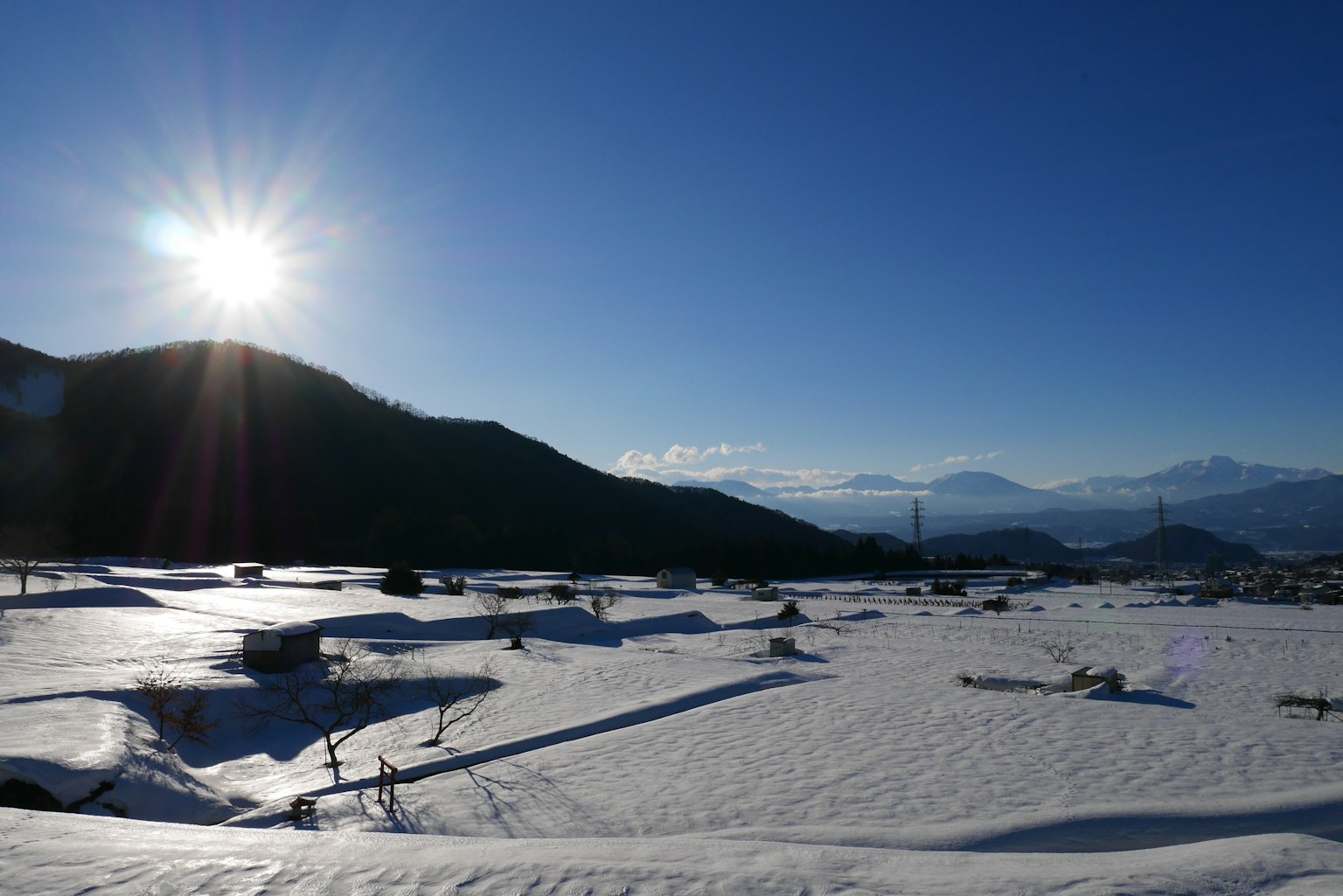 Paysage enneigé avec le soleil brillant dans un ciel bleu clair