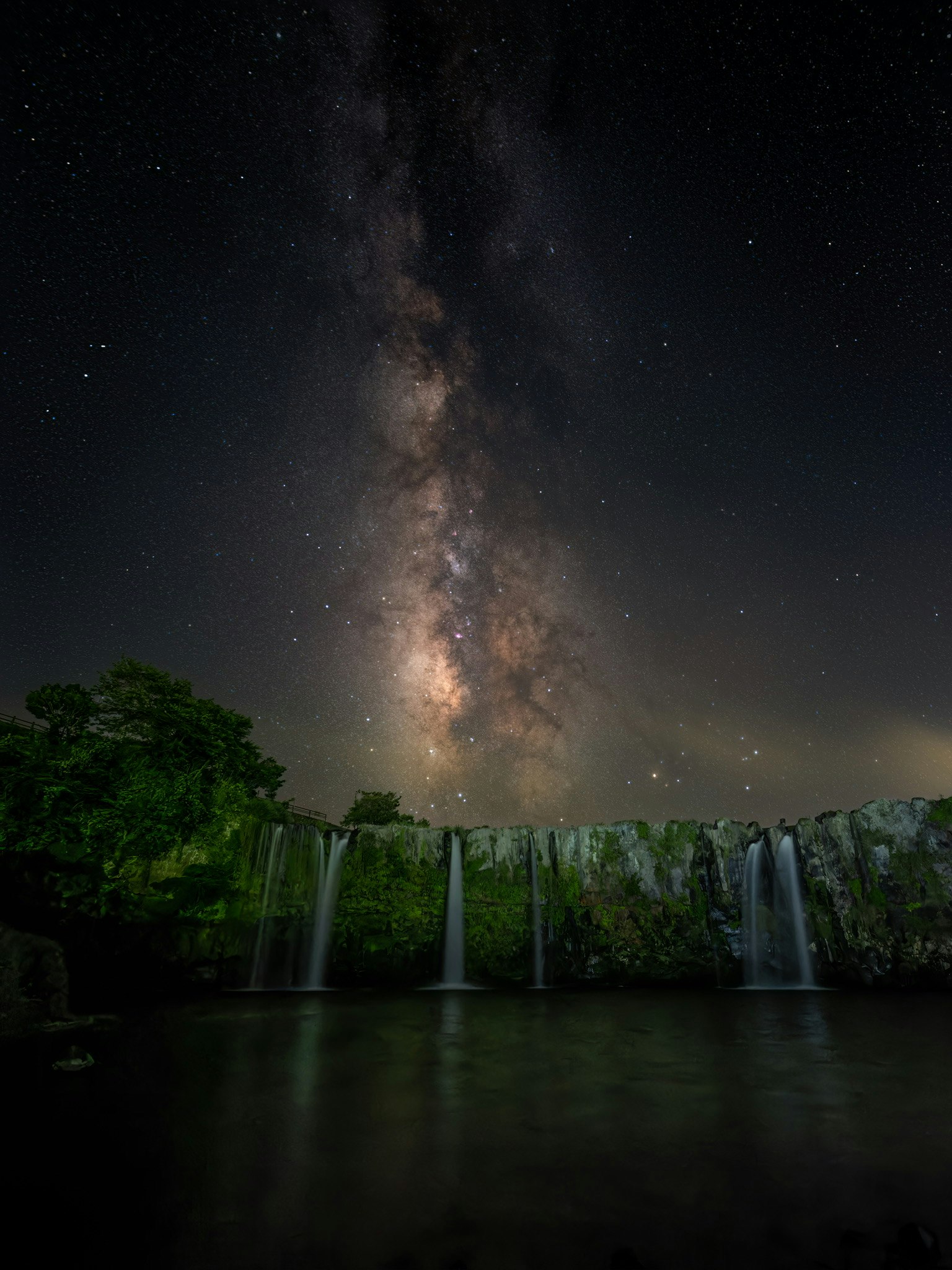 原尻の滝の夜空に広がる天の川のような星空と水面