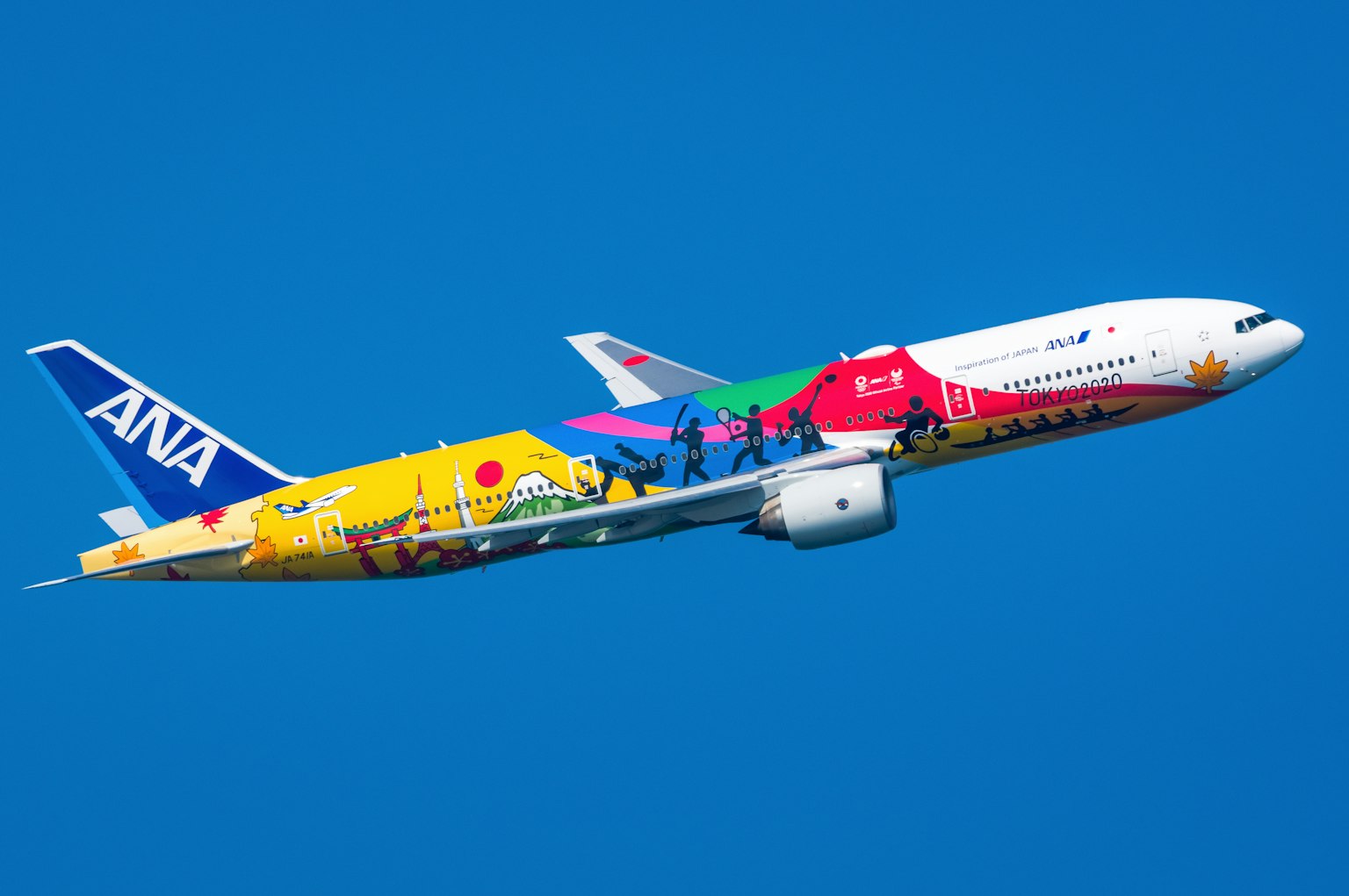 Buntes ANA-Flugzeug fliegt gegen einen blauen Himmel
