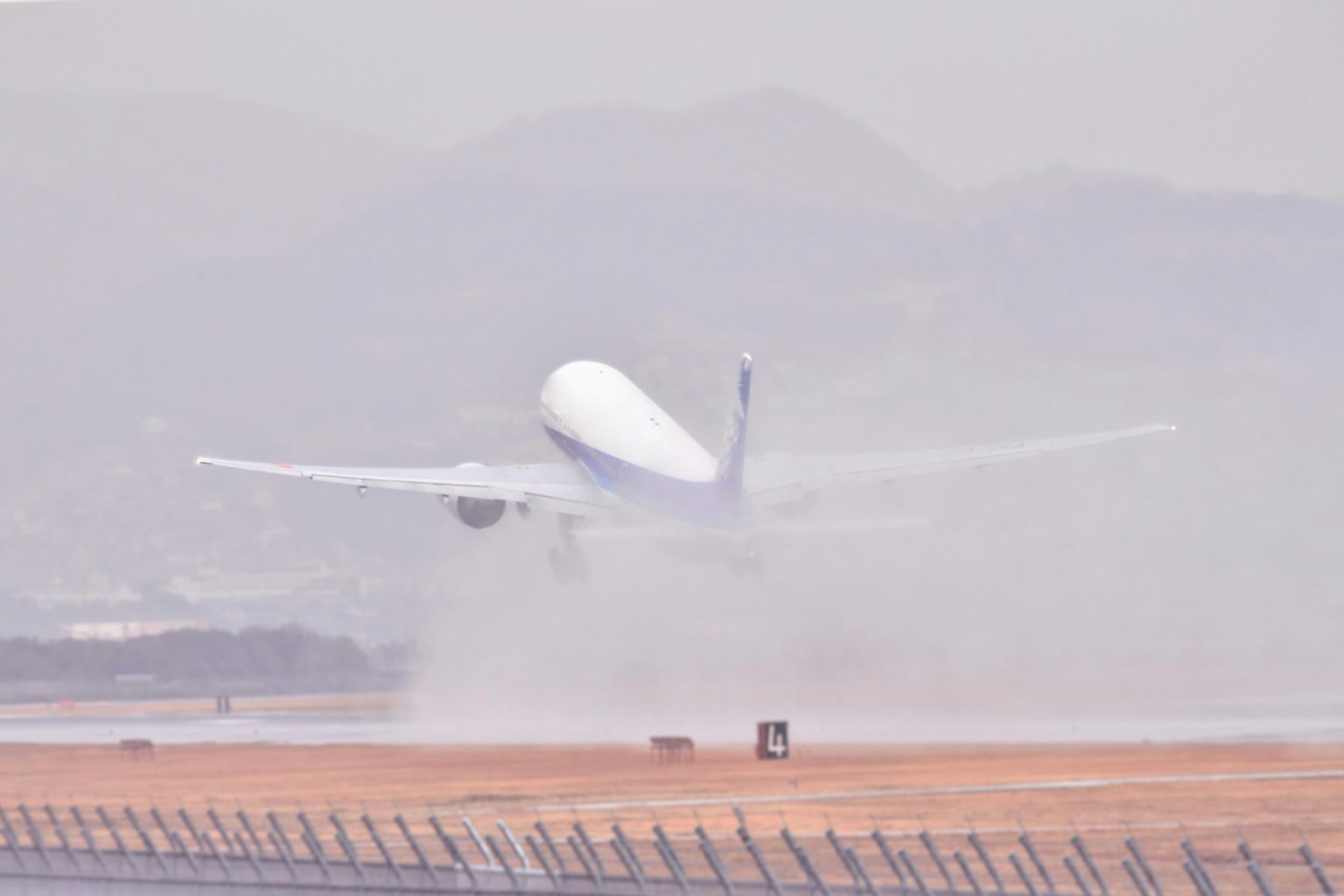 Avión despegando de la pista con polvo y humo detrás