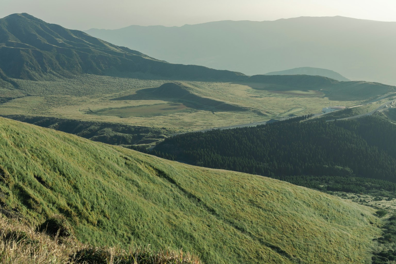 Weitläufige Aussicht auf grüne Wiesen und Berge