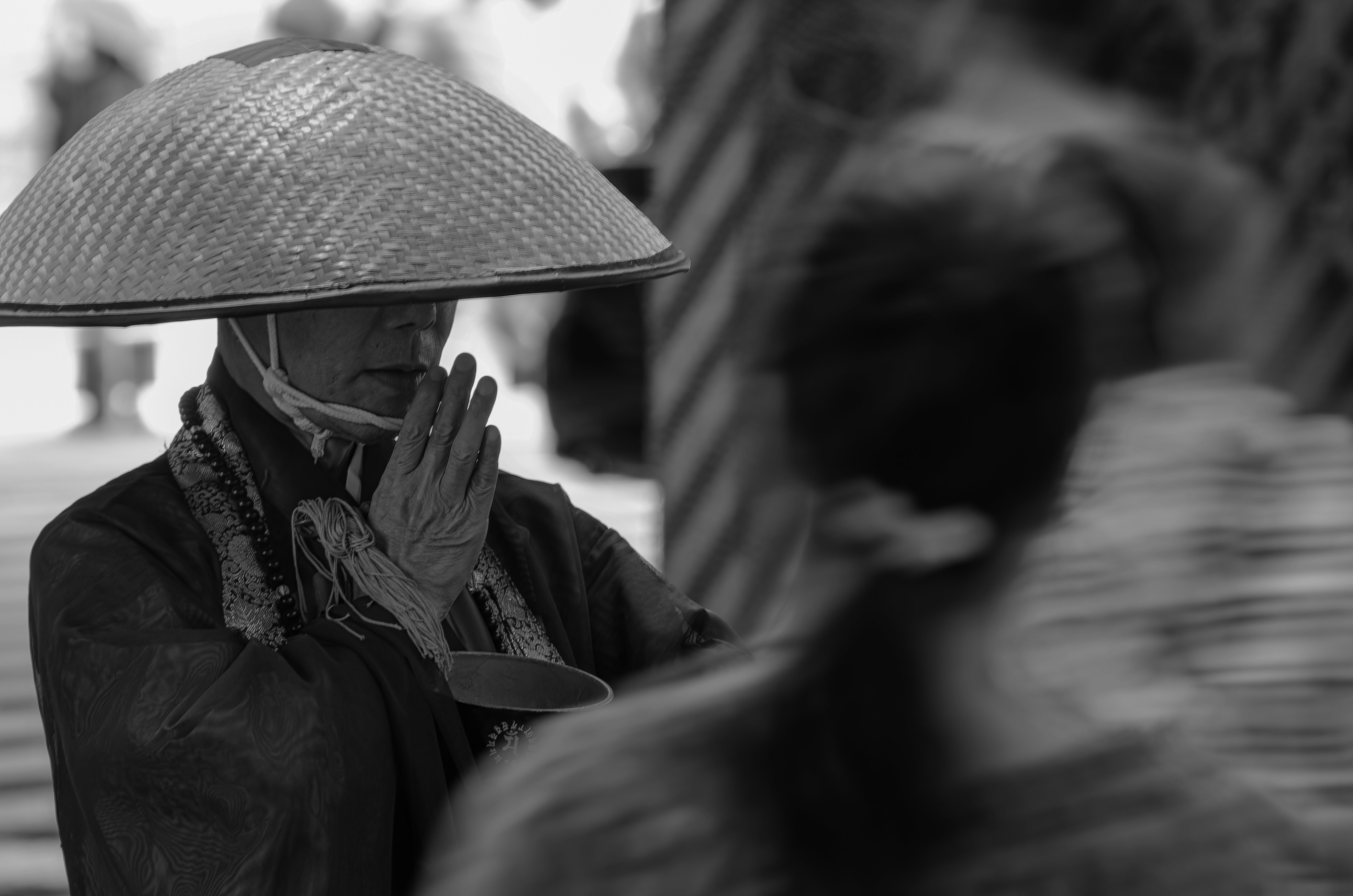 Người cầm ô dưới mưa với người đi đường bị nhòe ở tiền cảnh