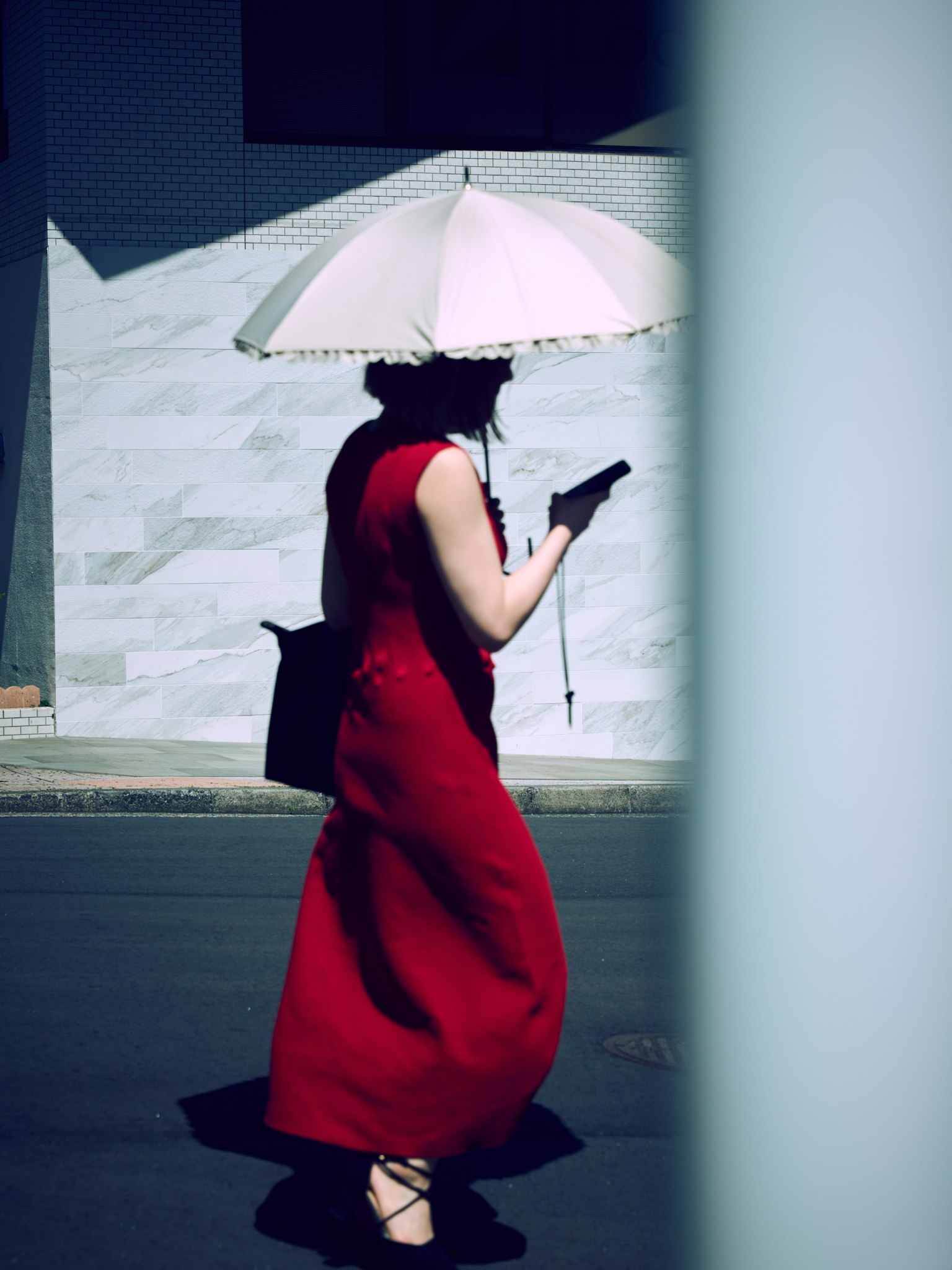 Donna in abito rosso che cammina con un ombrello