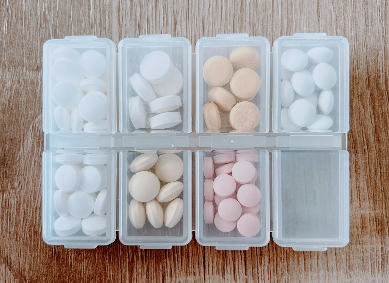 Assortimento organizzato di pillole bianche e rosa in un organizzatore trasparente