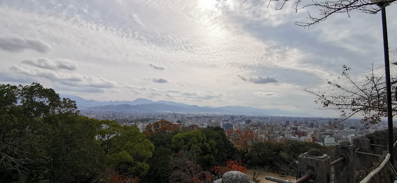 Vista panoramica di montagne e città con alberi colorati