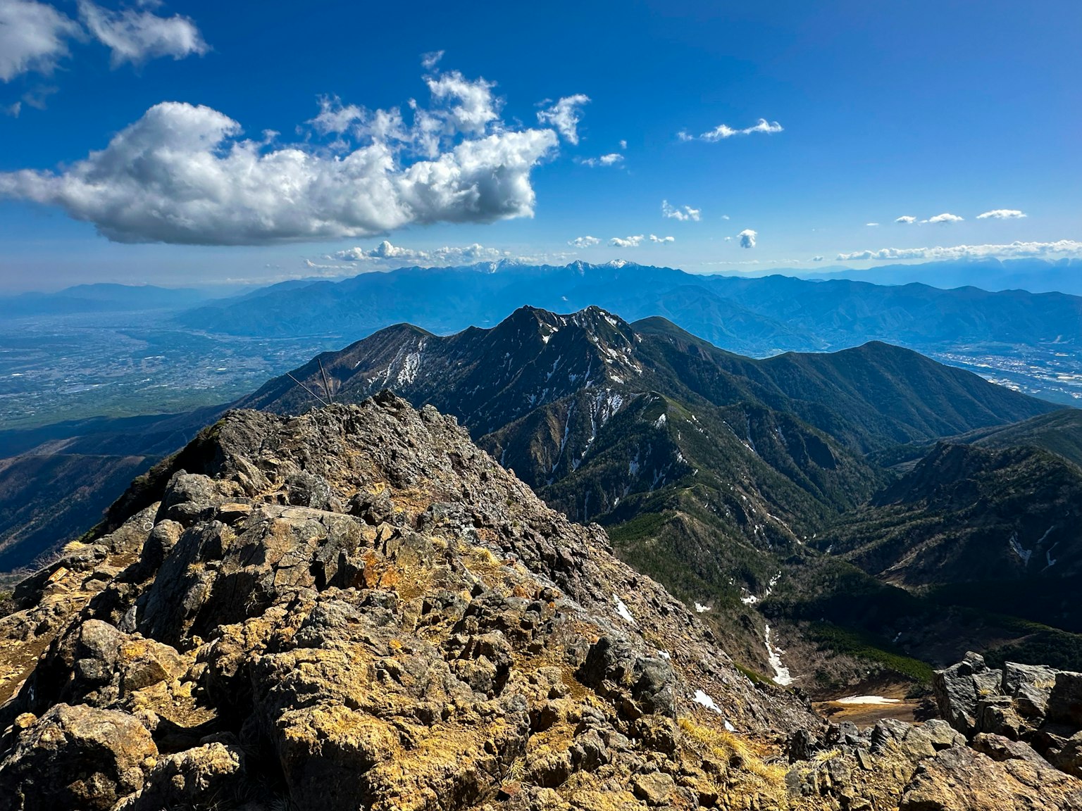 Aussicht vom Berggipfel mit blauem Himmel und Wolken entfernten Bergen felsige Oberfläche