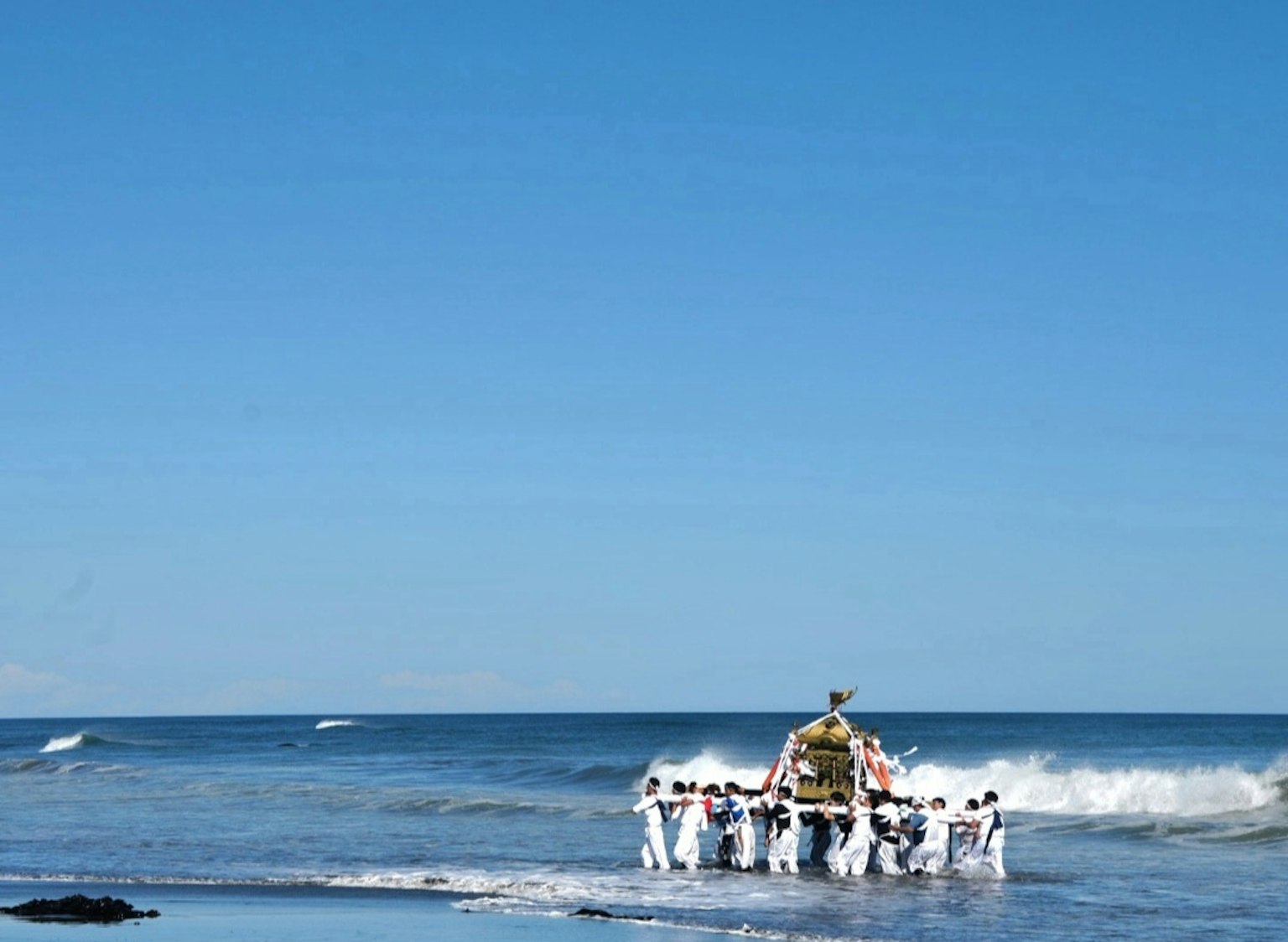 Scène de festival avec des personnes portant un sanctuaire portable sur la plage ciel bleu et vagues