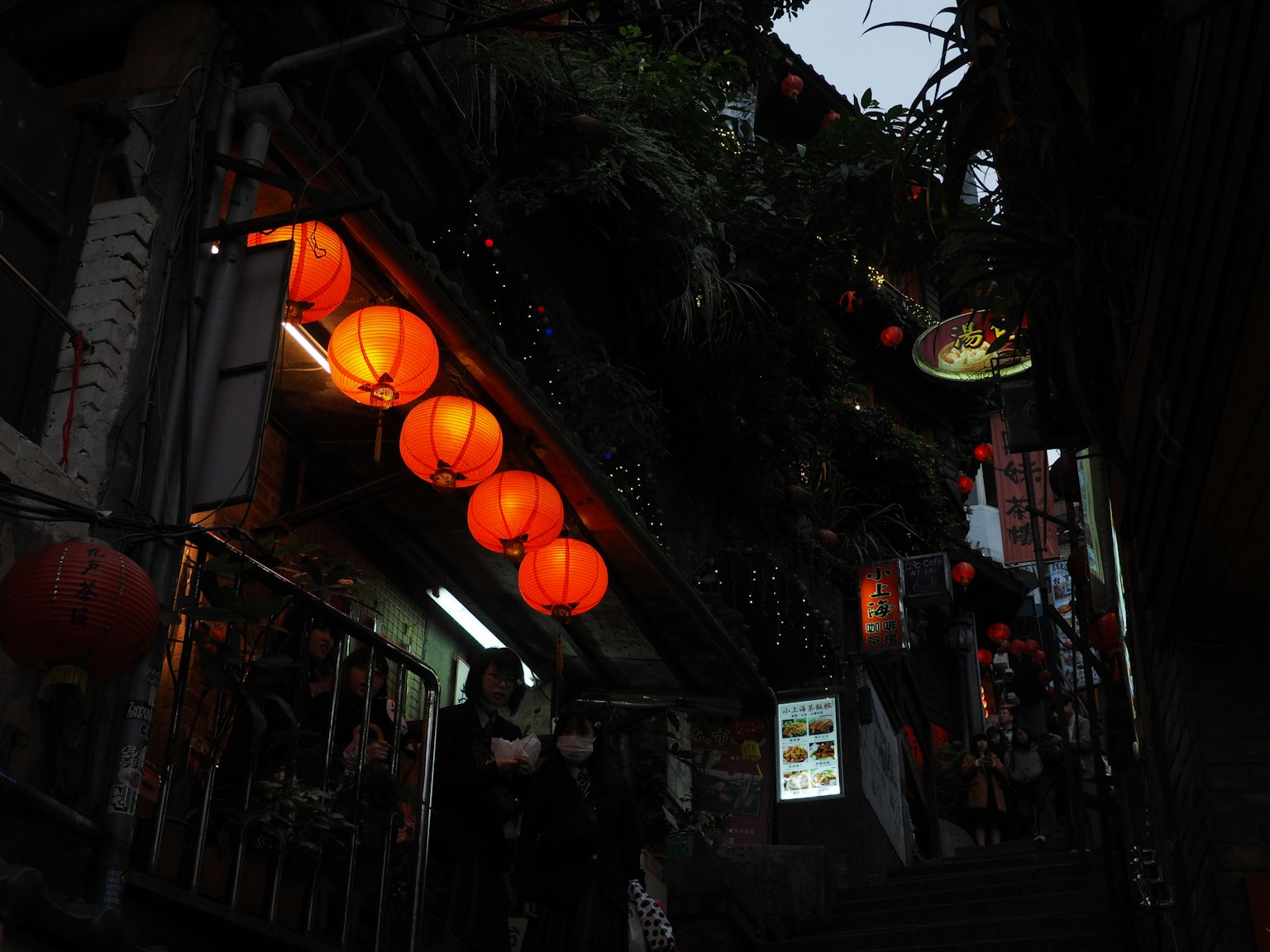 Scène de rue nocturne avec des lanternes rouges brillantes et des personnes