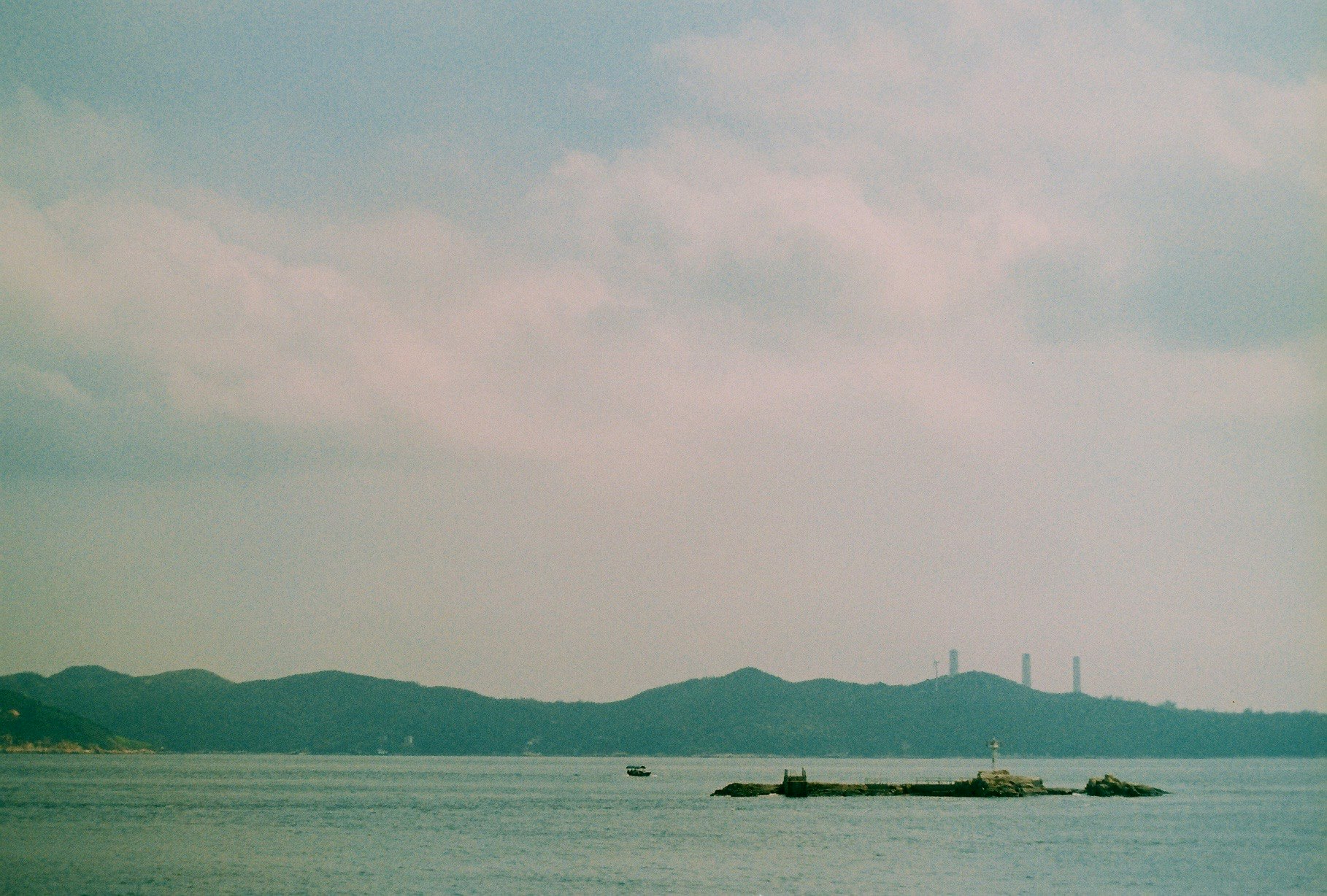 海に浮かぶ小島と遠くの岬のある風景