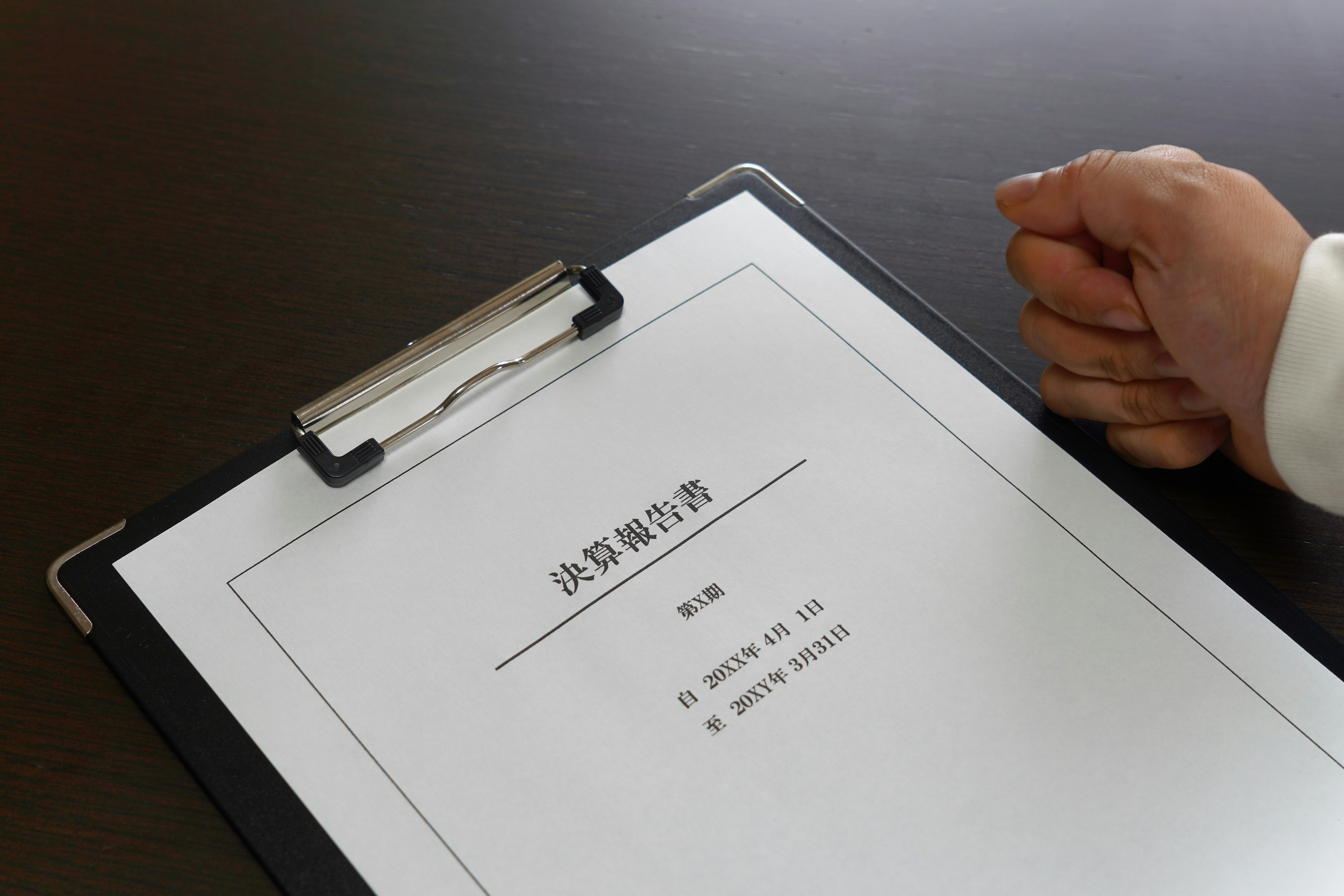 tay đang xem tài liệu trên bàn làm việc