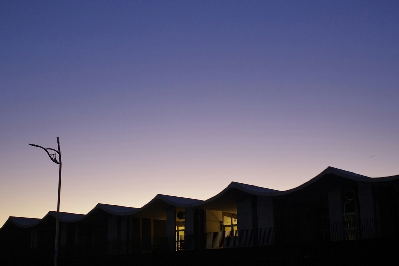 夕暮れ時の建物のシルエットと明かり