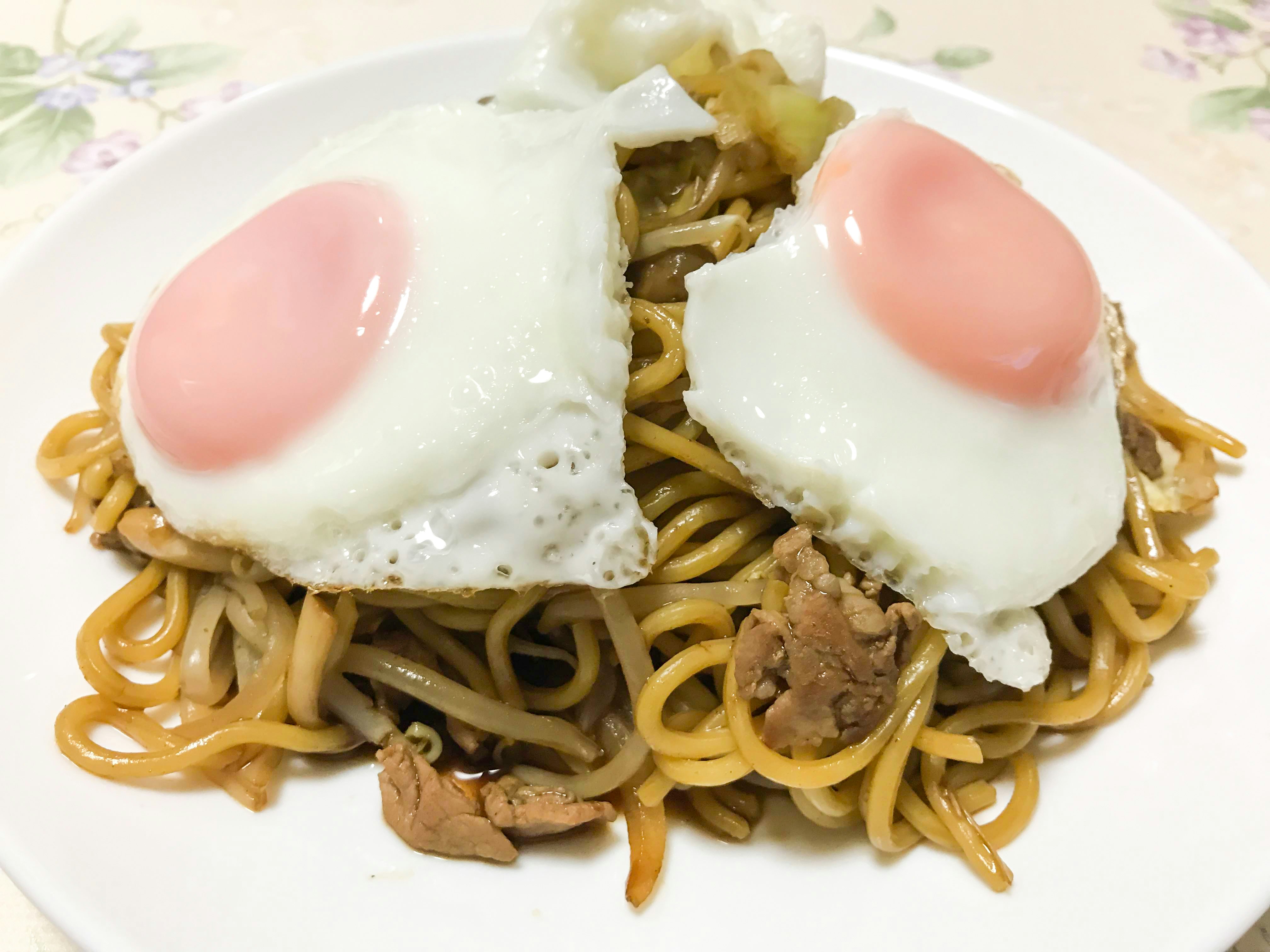 plate of yakisoba with two fried eggs