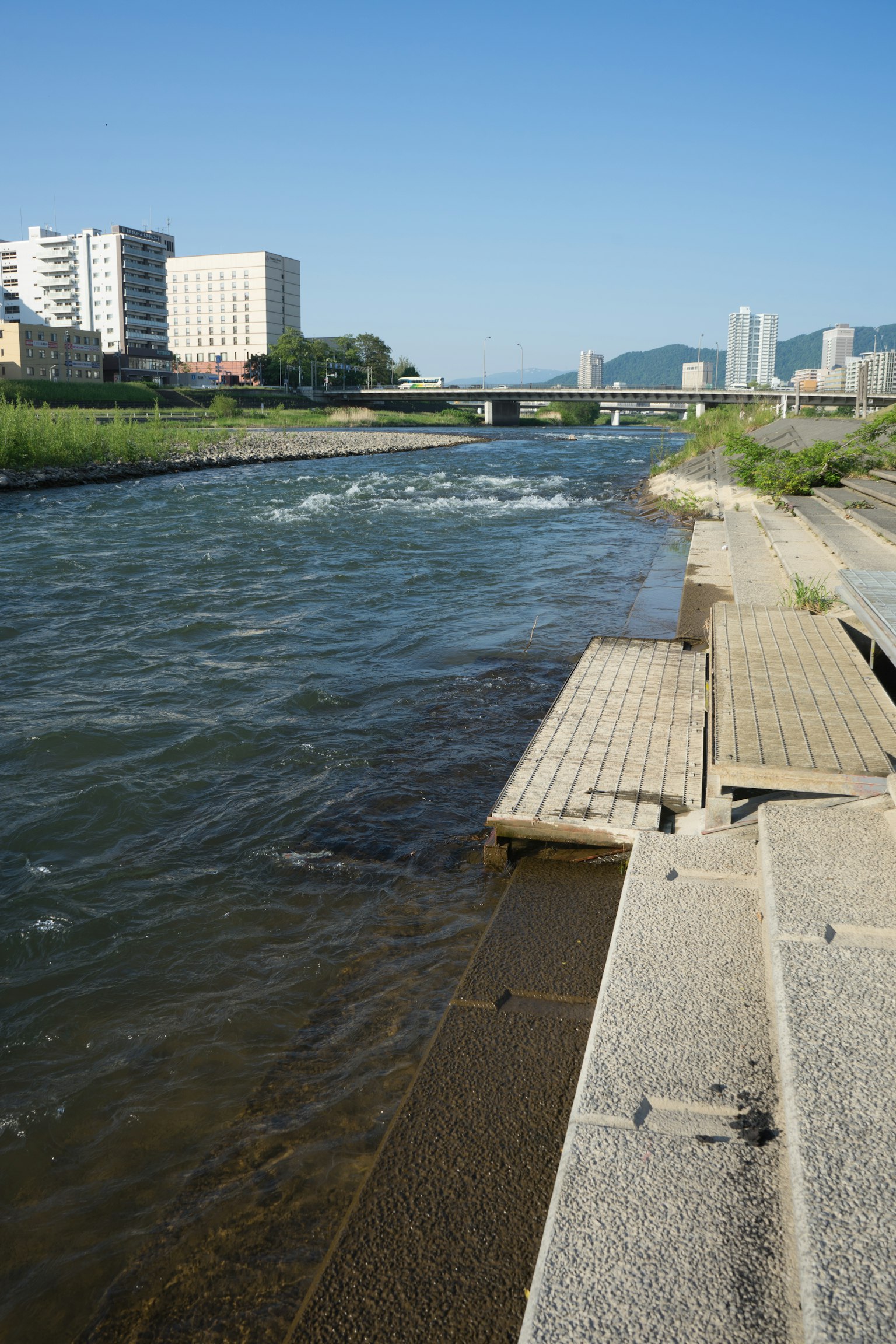 Vue pittoresque d'une rivière avec des bâtiments et un pont en arrière-plan