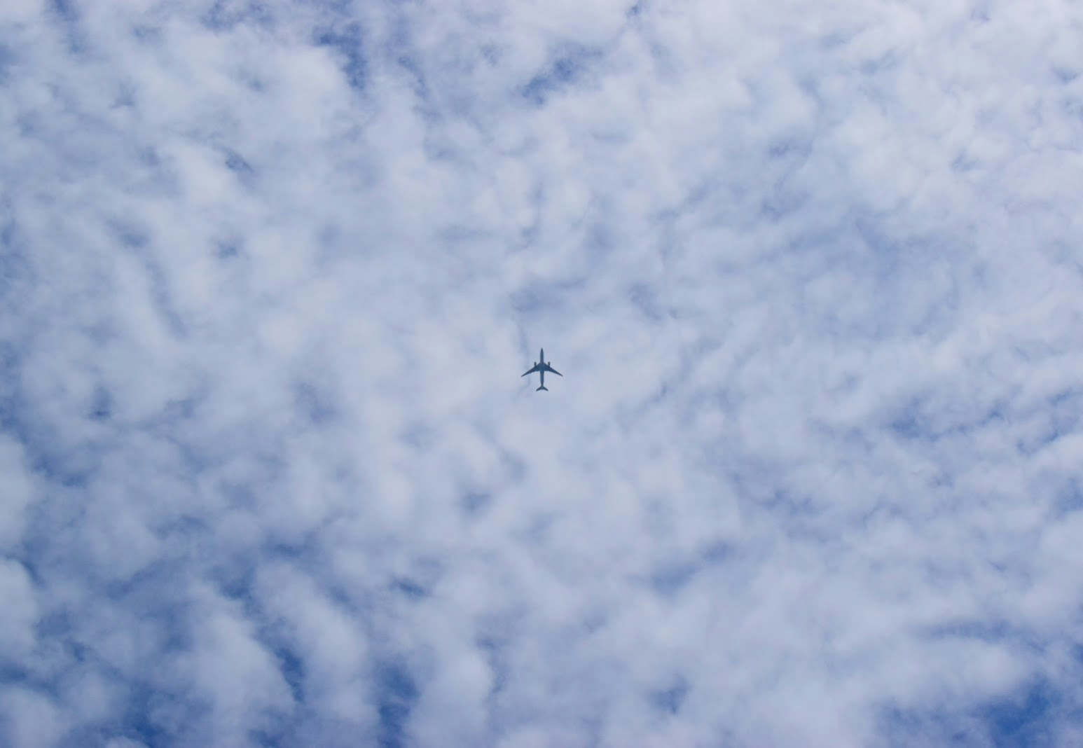 雲の下を飛ぶ飛行機のある曇り空