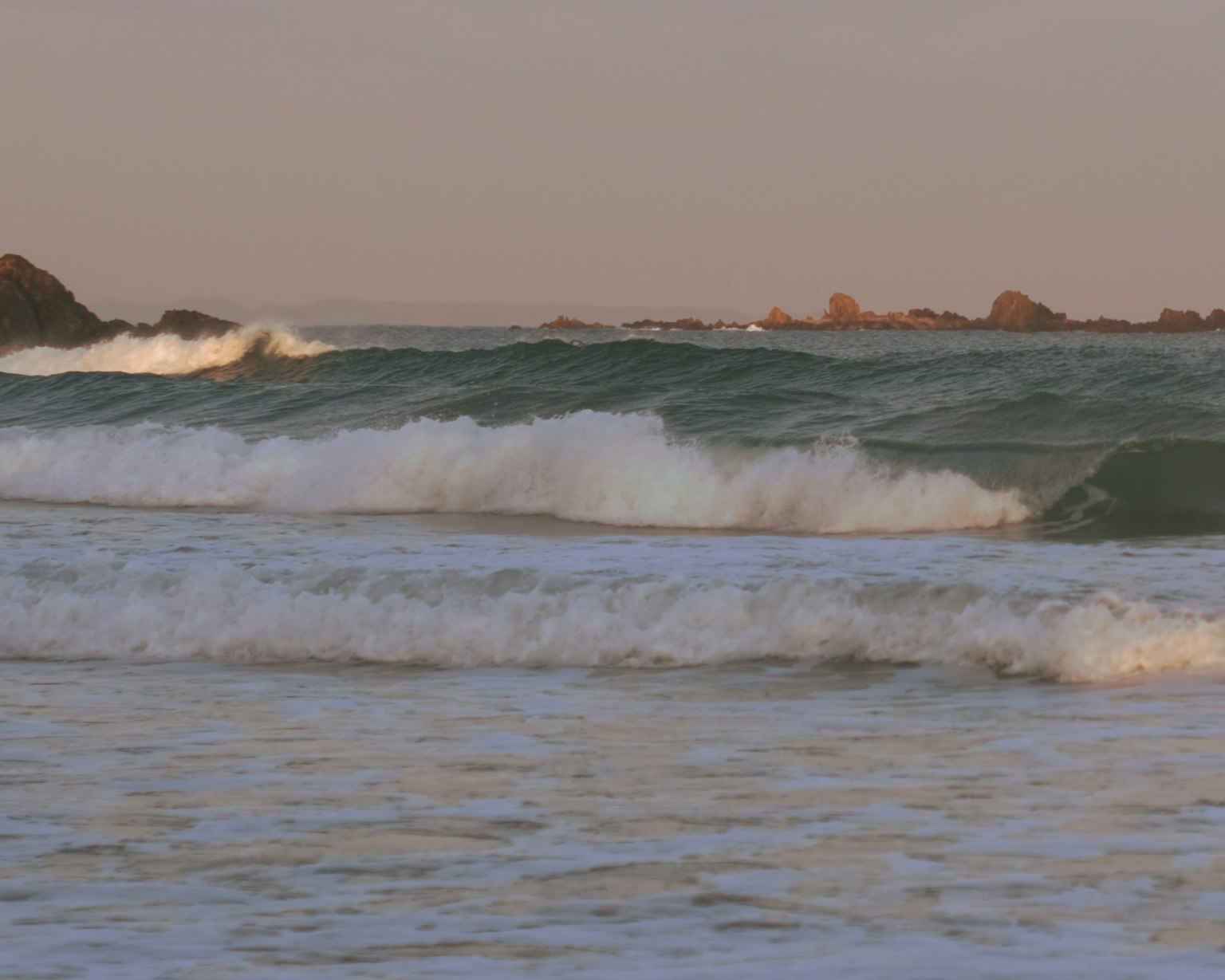 Vagues calmes sur une plage au coucher du soleil