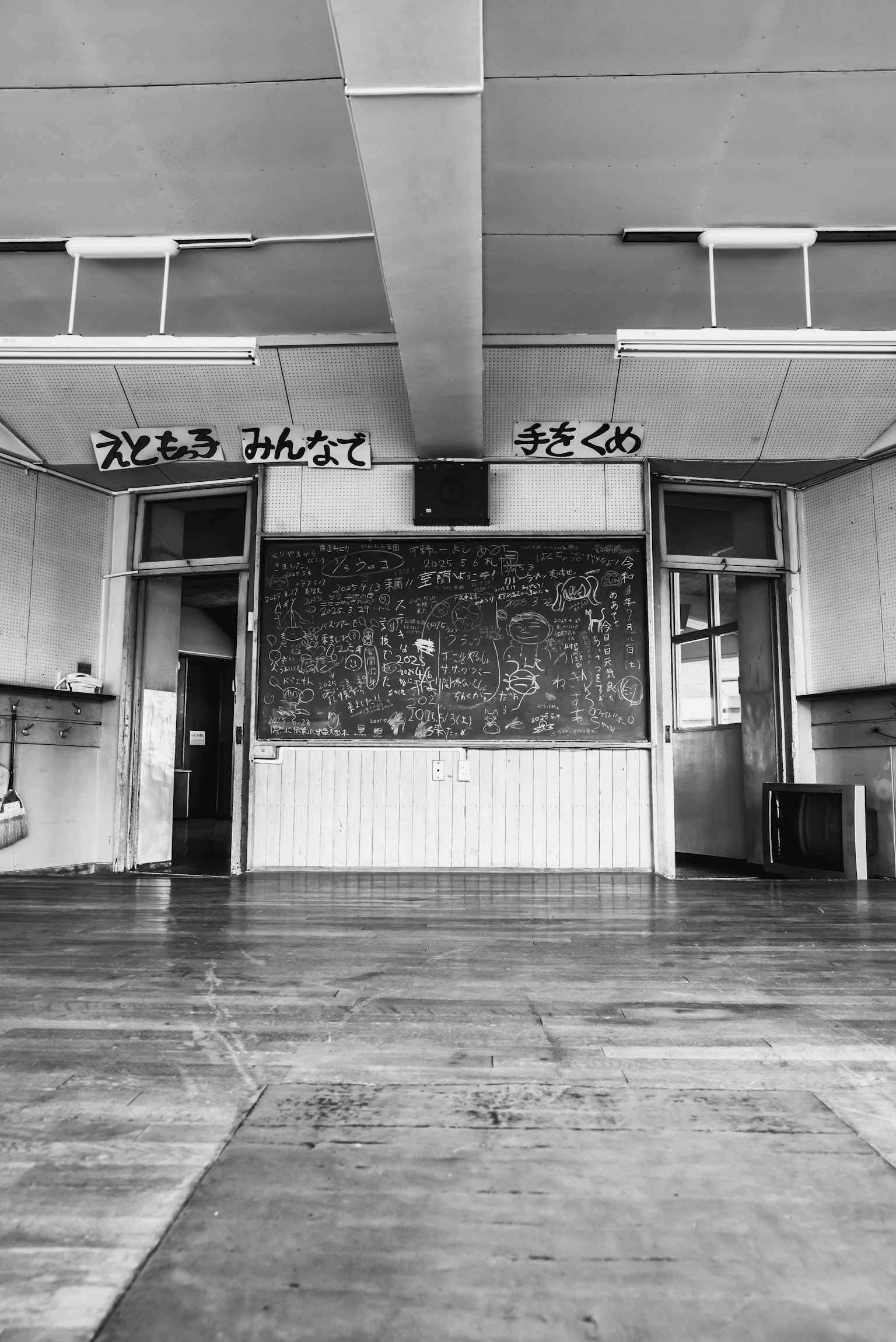 Interior de un aula con pizarra y suelo de madera