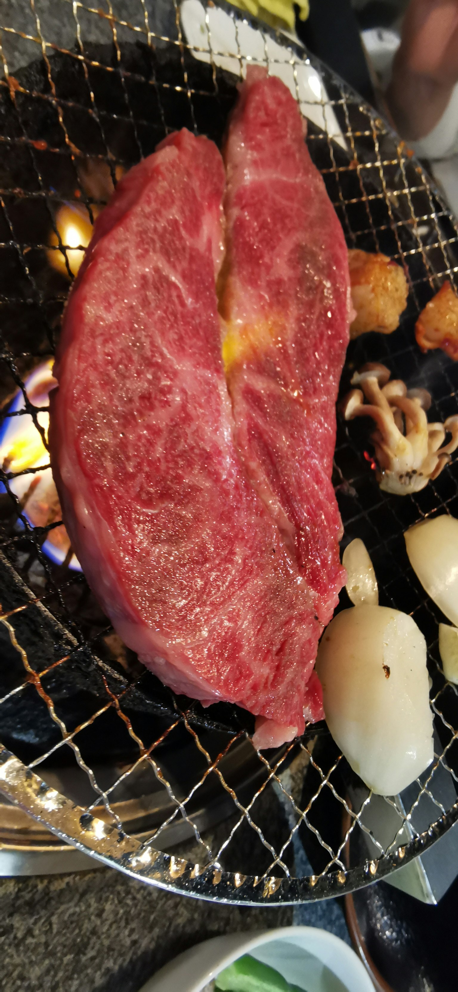 Grand morceau de viande rouge grillé sur charbon avec des légumes