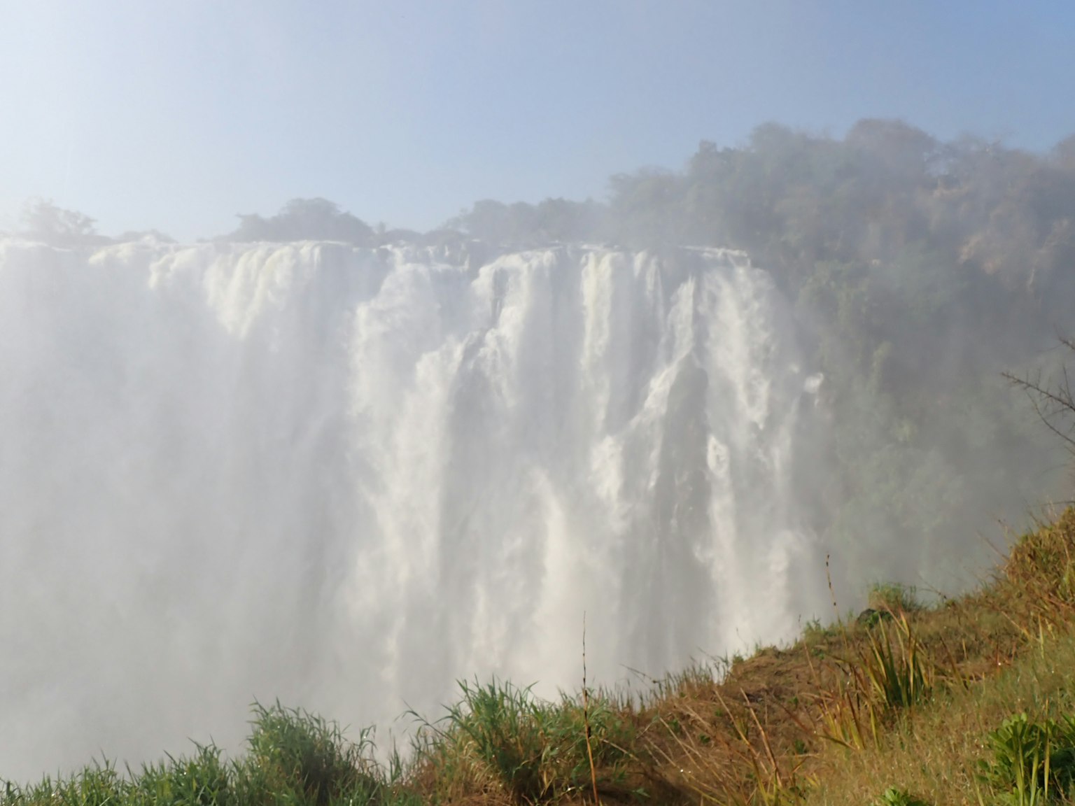Air terjun megah dengan kabut dan vegetasi yang subur