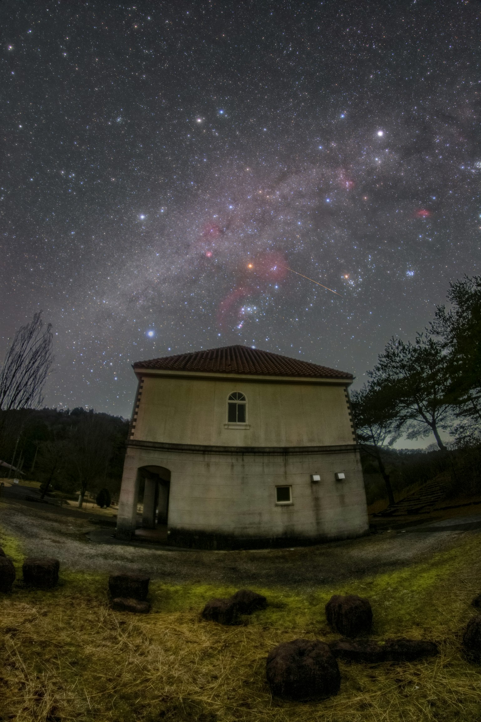 Edificio sotto un cielo stellato con natura circostante