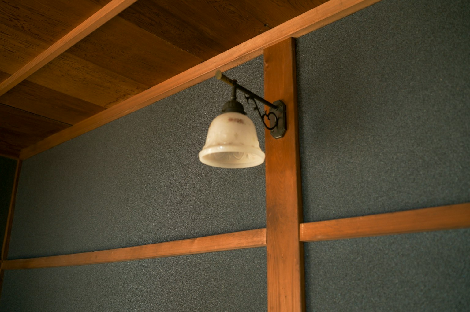 White bell mounted on a wooden wall