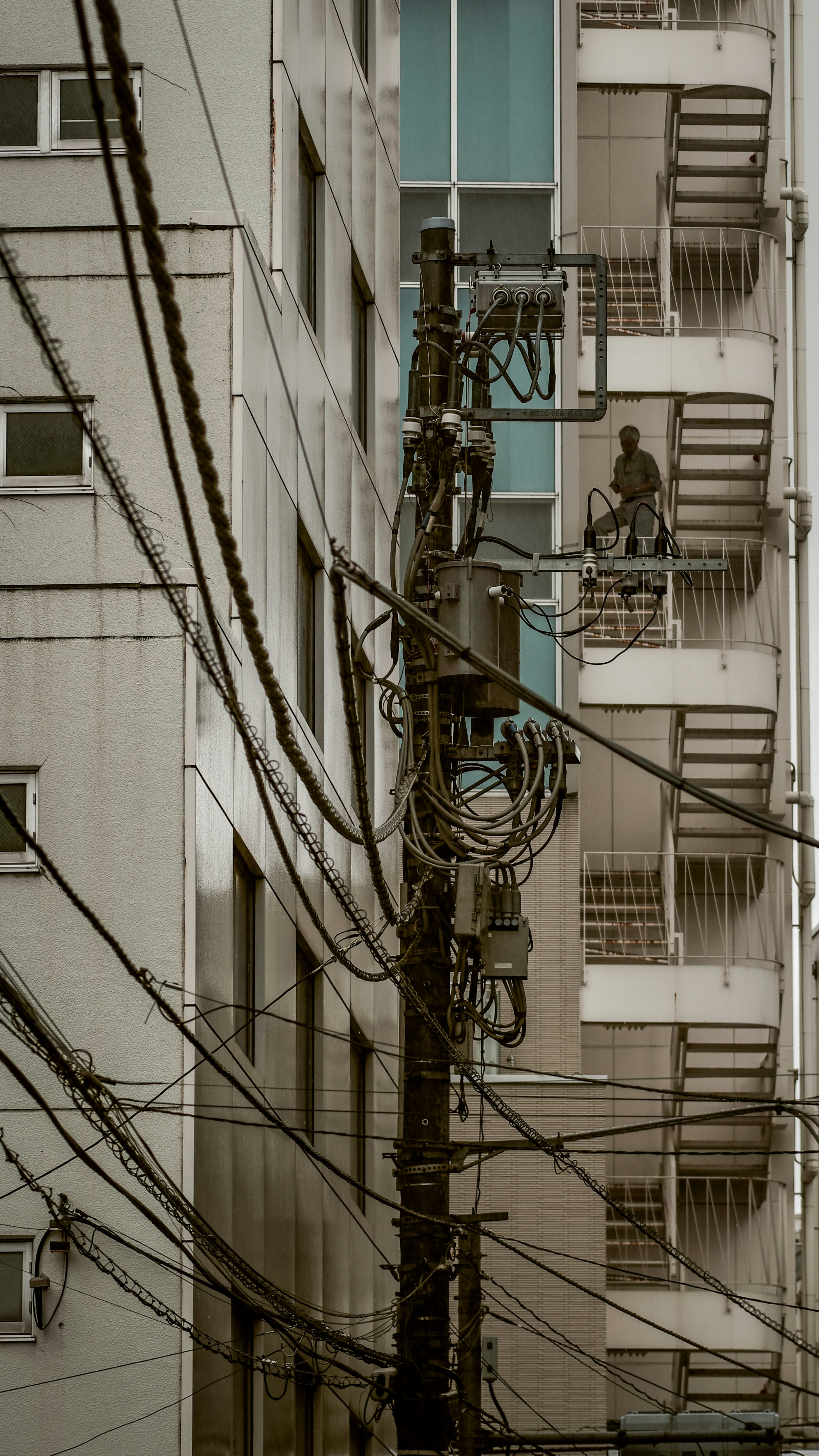 電柱と電線が交差する都市の建物外壁