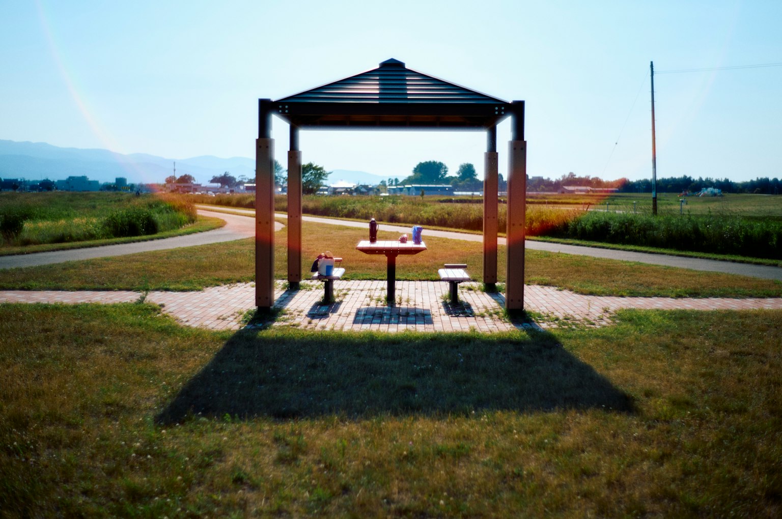 Pavillon en bois avec une table dans un vaste champ herbeux