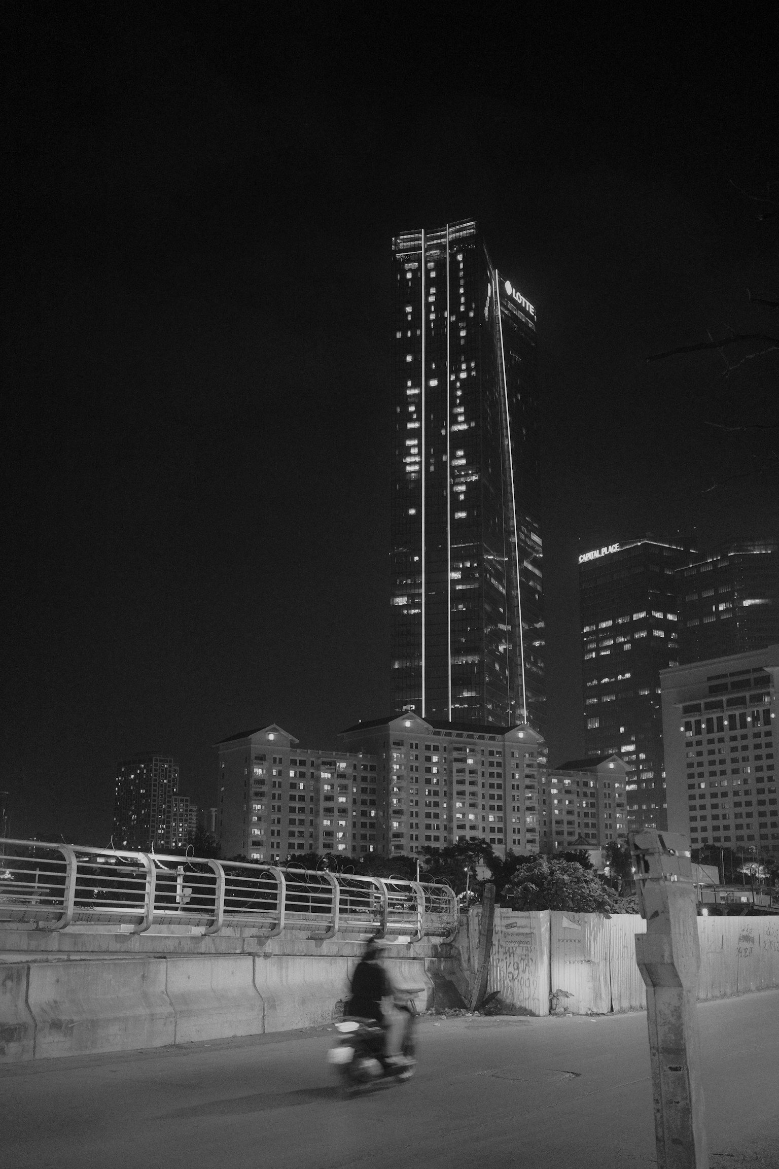夜间城市景观 以摩托车和摩天大楼为特色的黑白照片