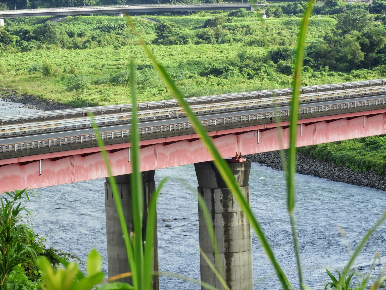 Un pont rouge traversant une rivière entourée de verdure luxuriante