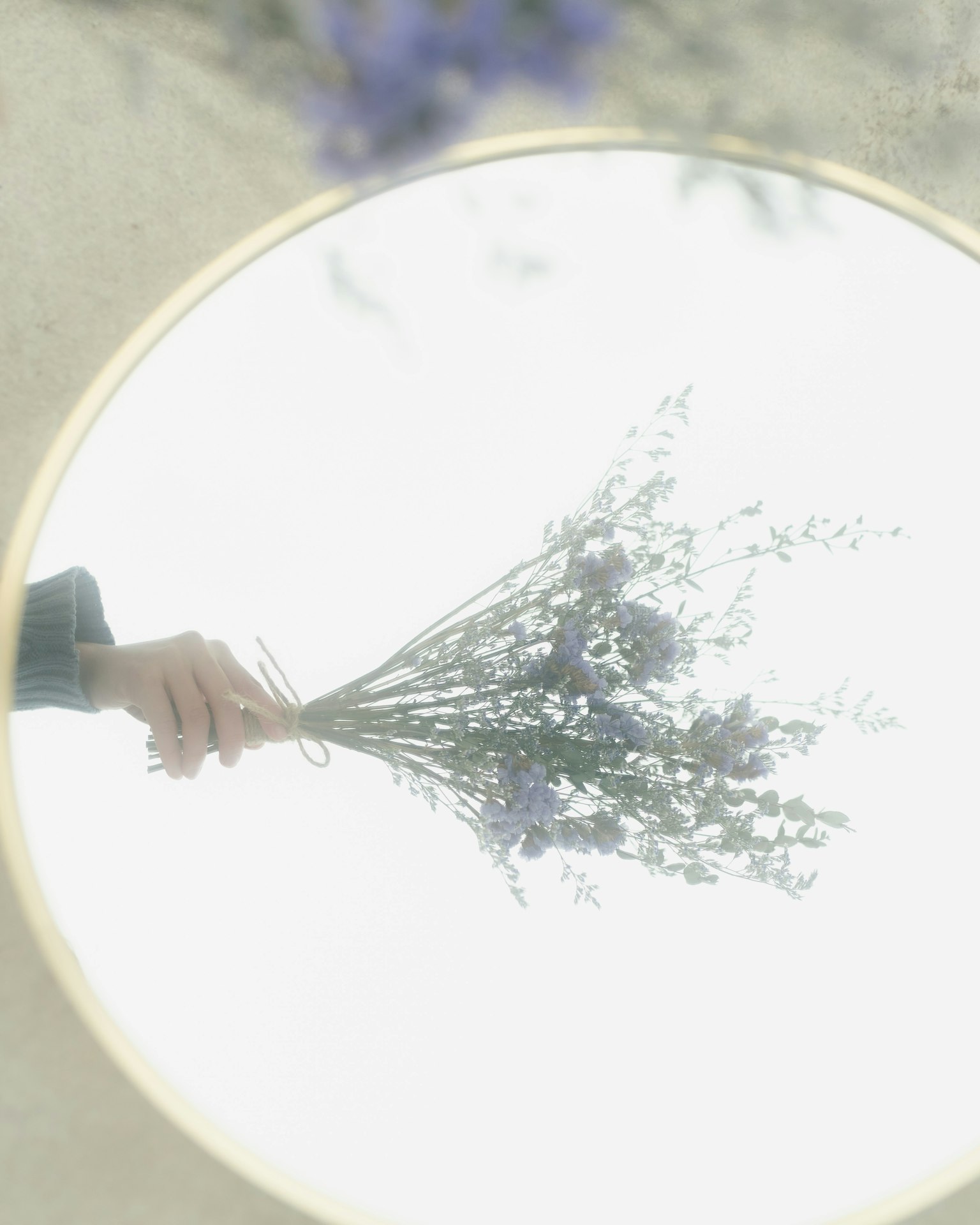 Un mazzo di fiori riflesso in uno specchio rotondo