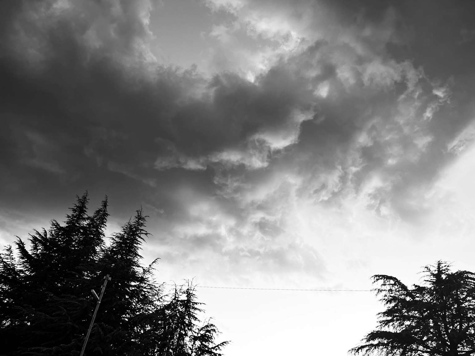 Awan gelap dengan pohon bersiluet di langit