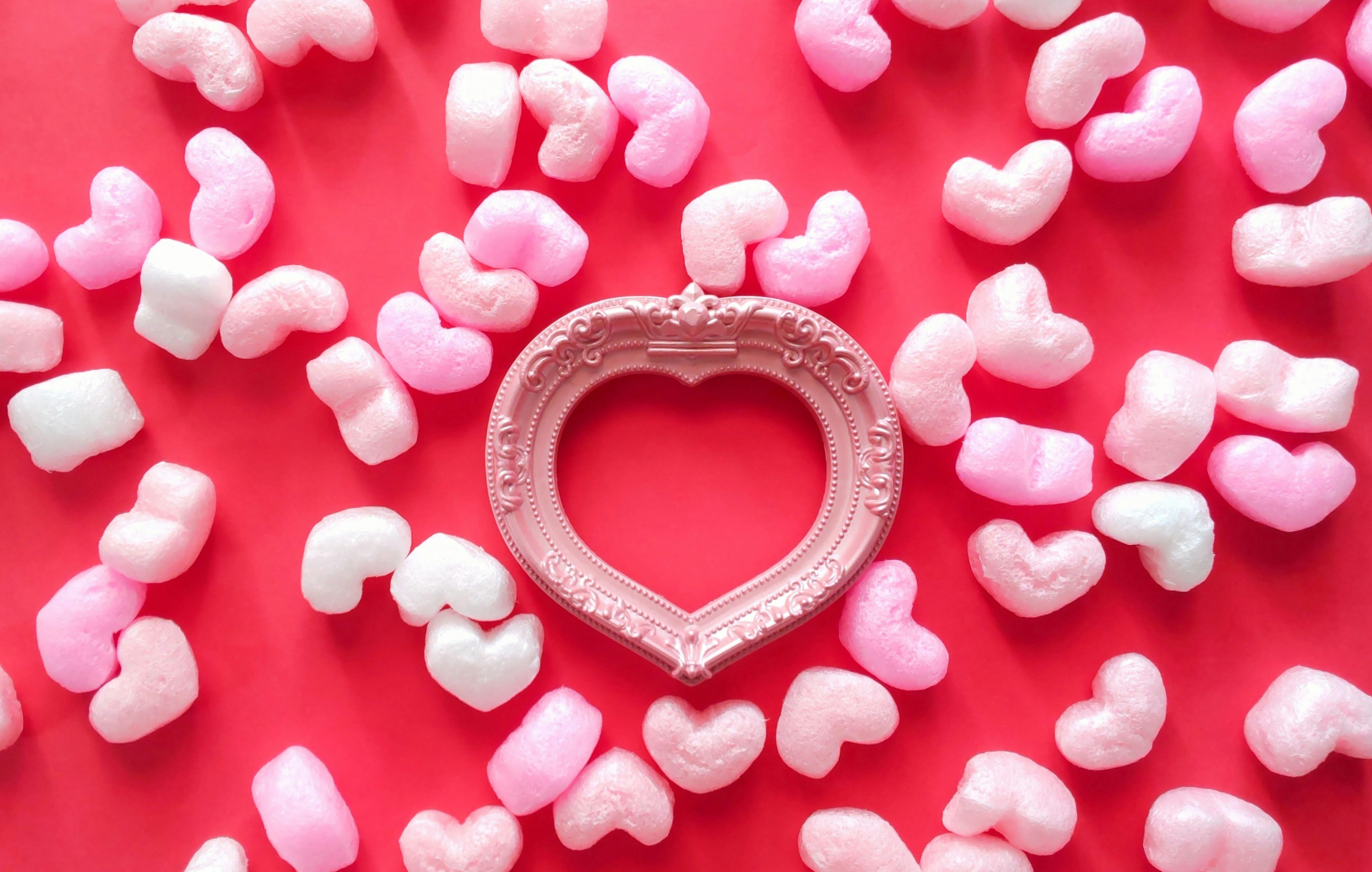 heart-shaped confetti and a heart frame on a red background for a celebration