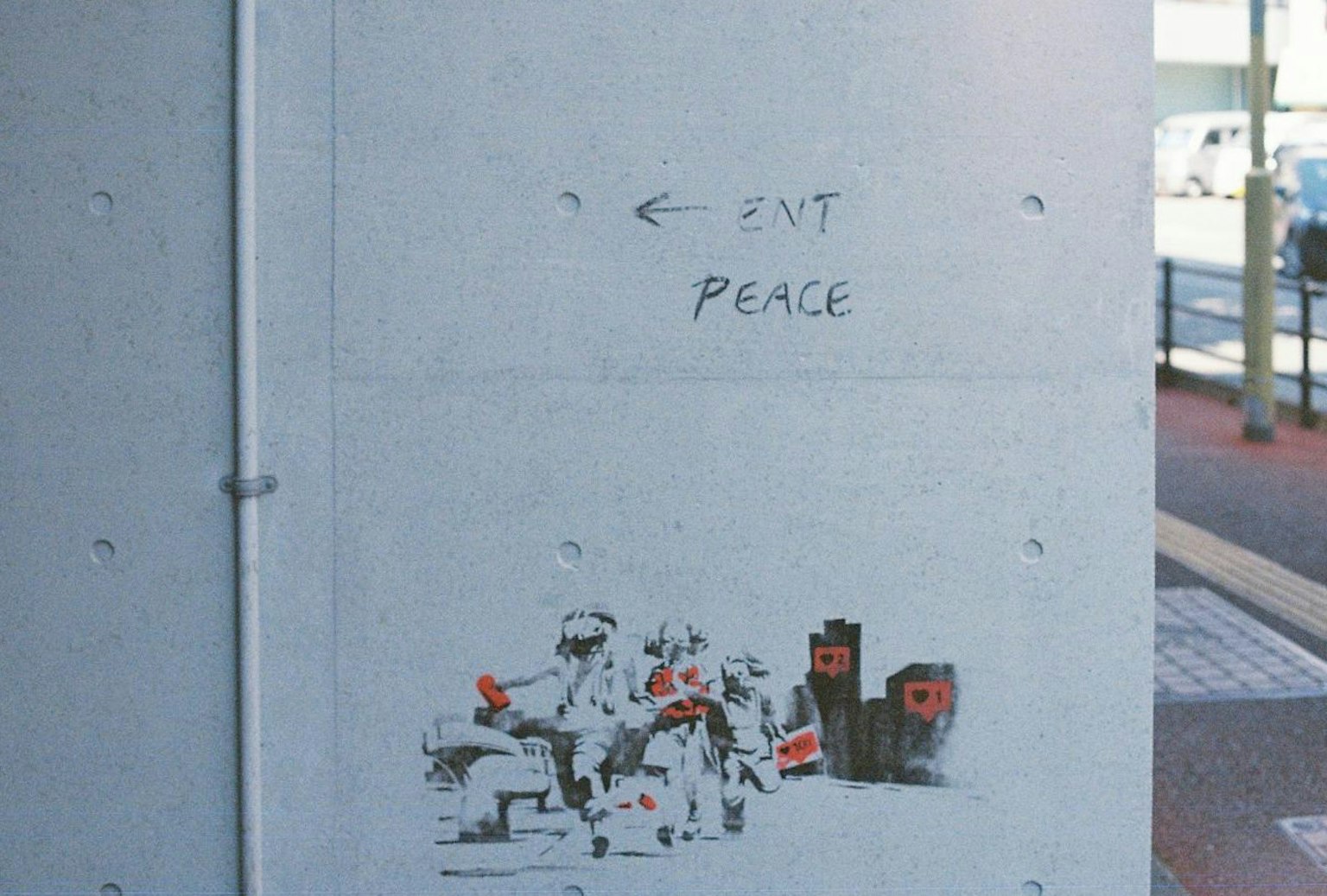 Arte di strada su un muro con personaggi in moto e le parole EXIT e PEACE