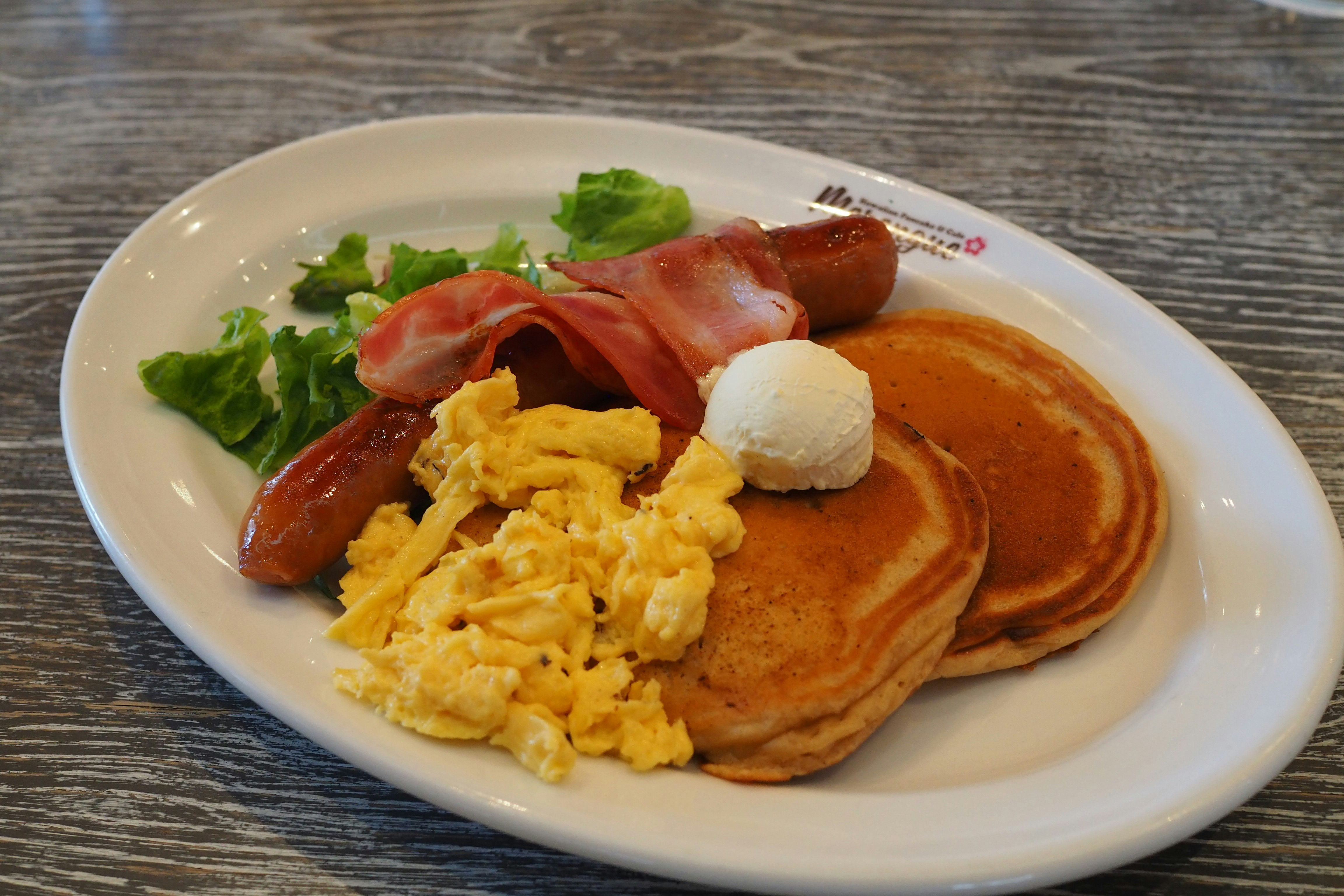 breakfast plate with pancakes, scrambled eggs and sausage