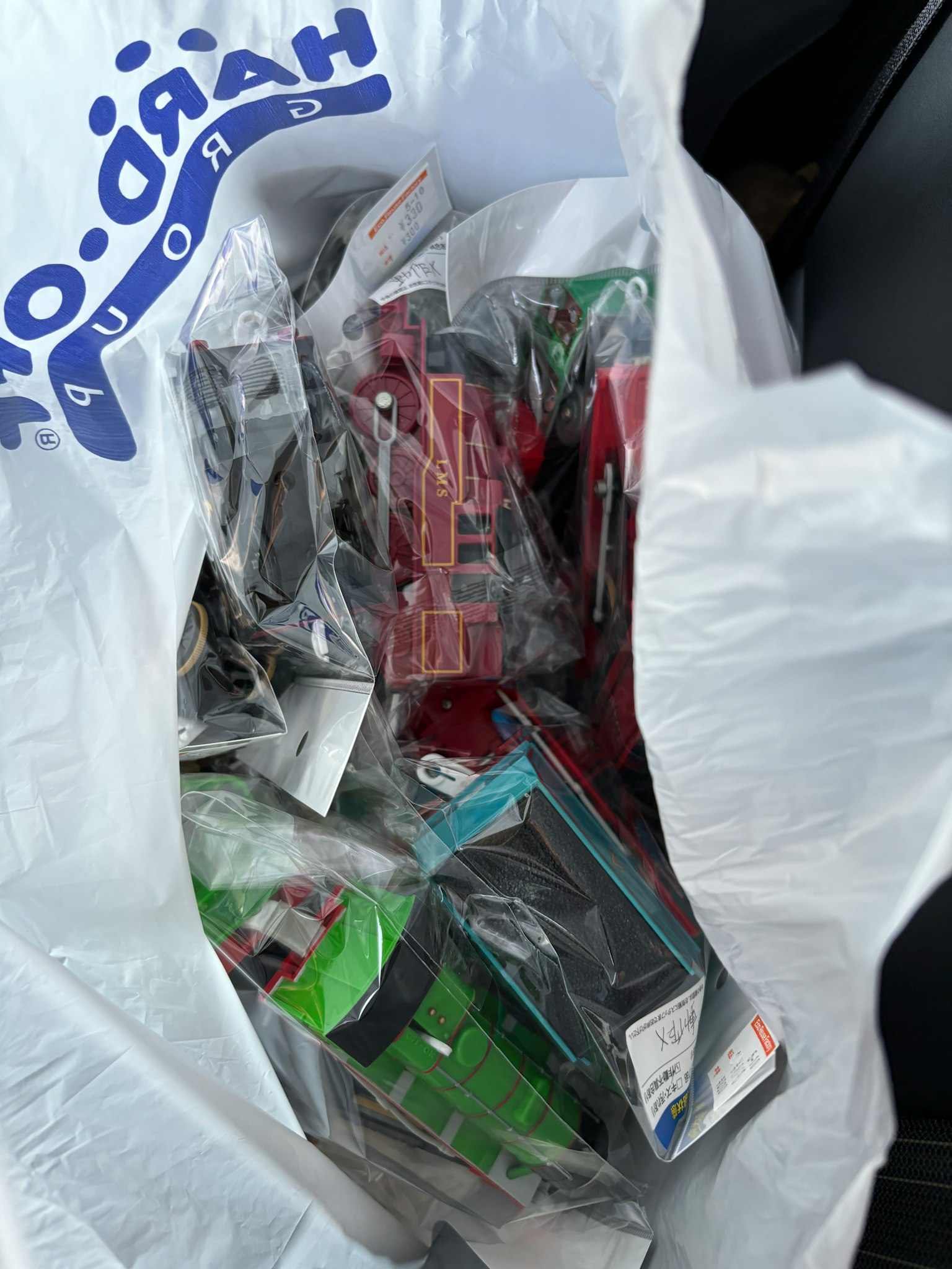 A white bag filled with various plastic toy packages