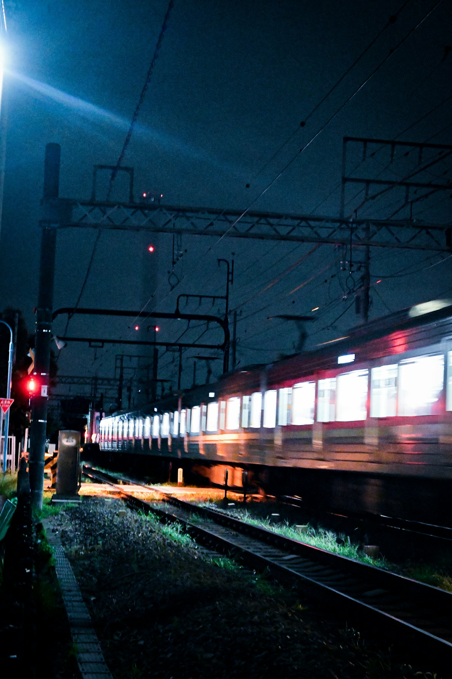 夜间行驶的列车，窗户亮着，信号灯