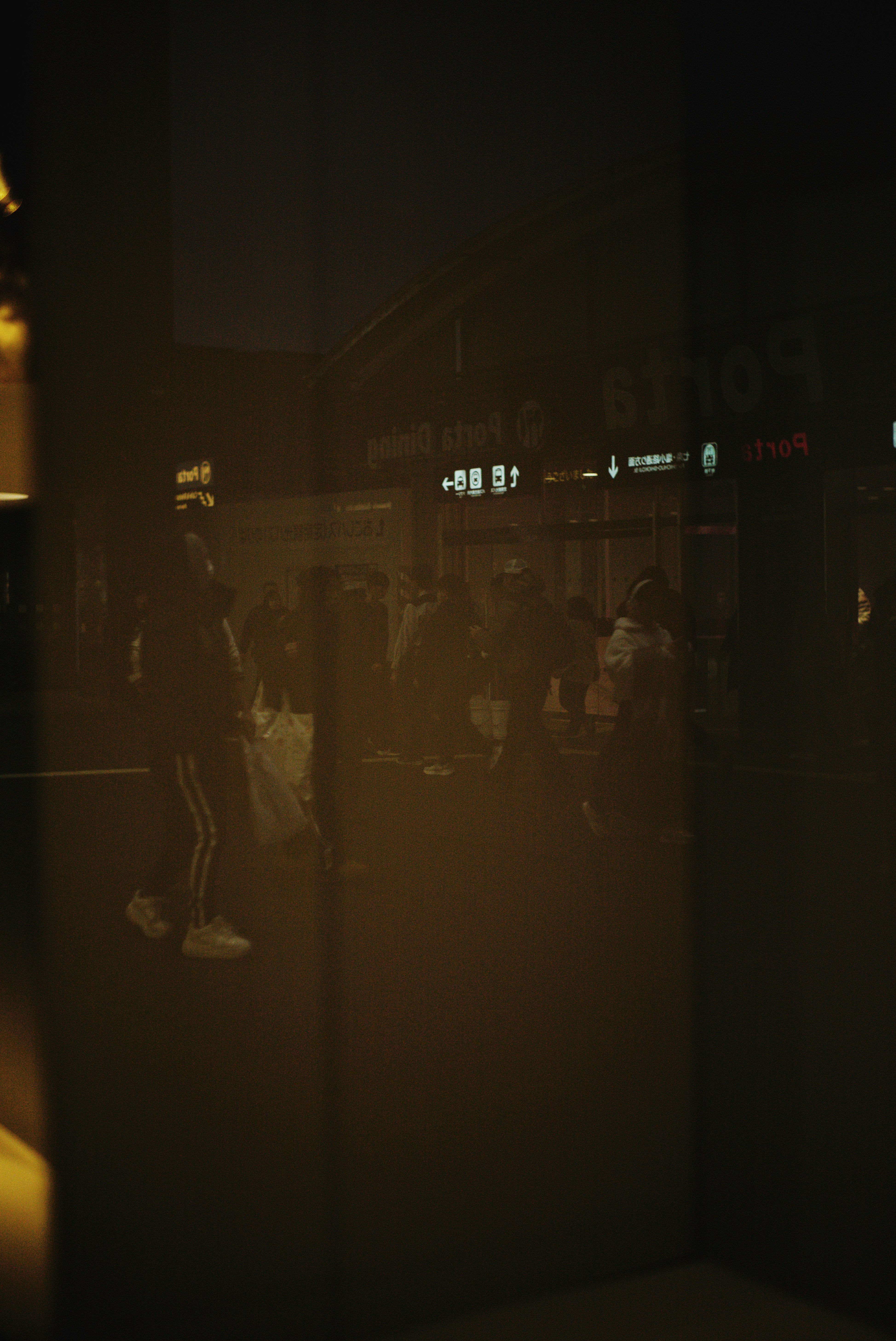 ガラス越しの夜の街並みと人影の反射