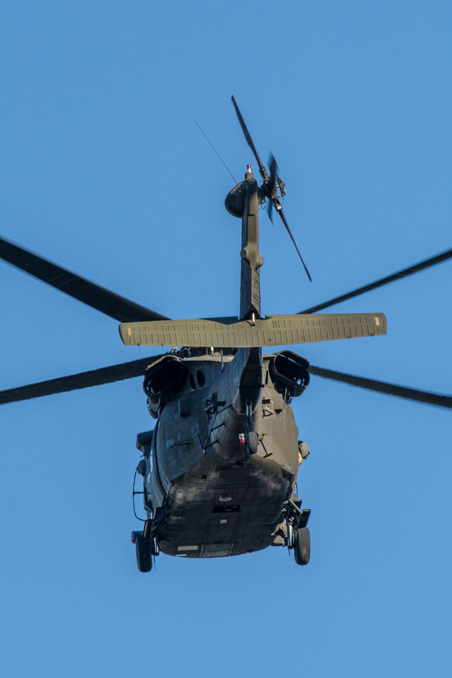 Hélicoptère militaire vu d'en bas contre un ciel bleu