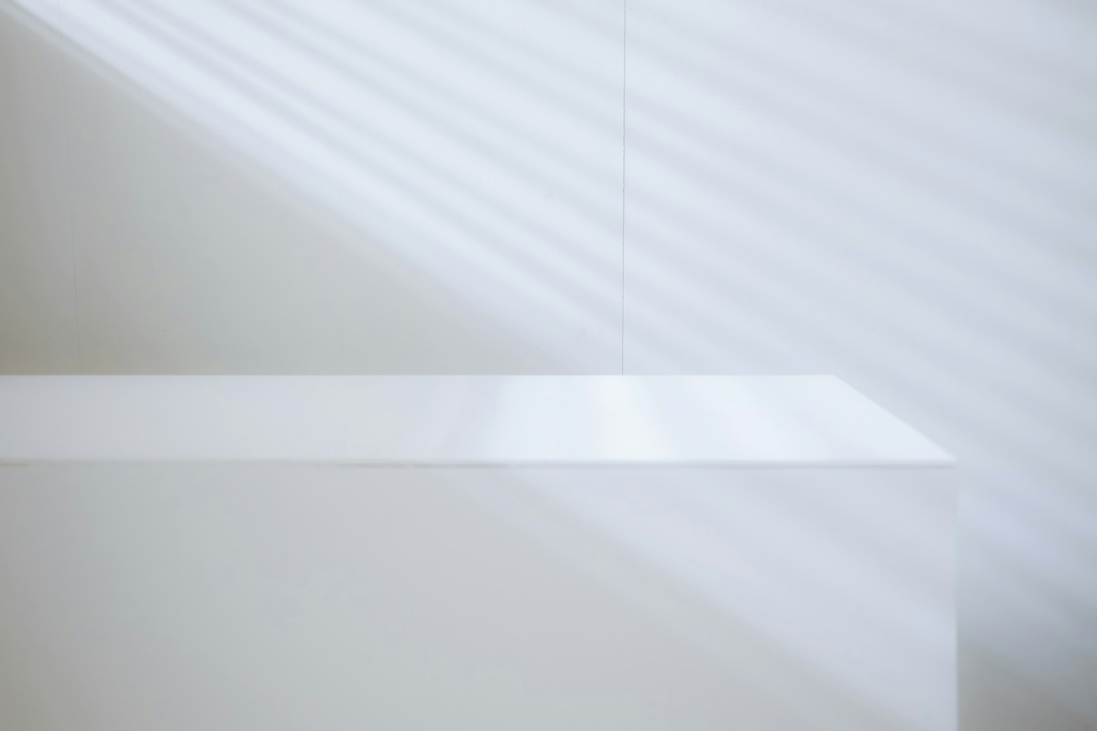 Weißer Hintergrund mit einem weißen Tisch und Lichtstrahlen