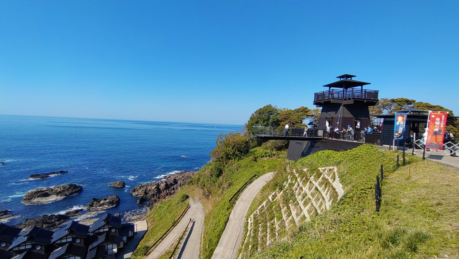 俯瞰蓝色海洋的绿色山丘上的观景塔美景