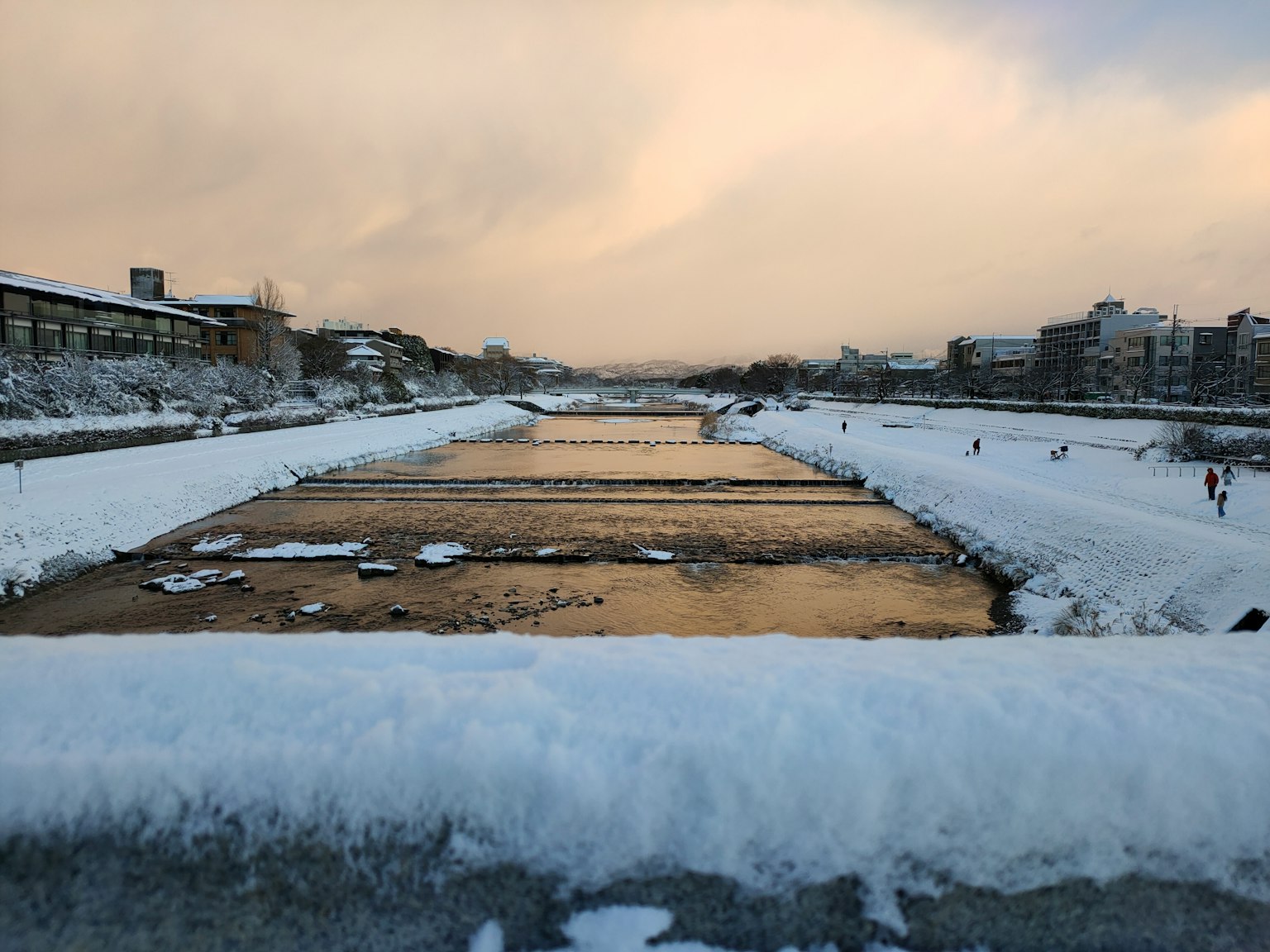 Schneebedeckter Fluss mit winterlichem Himmel