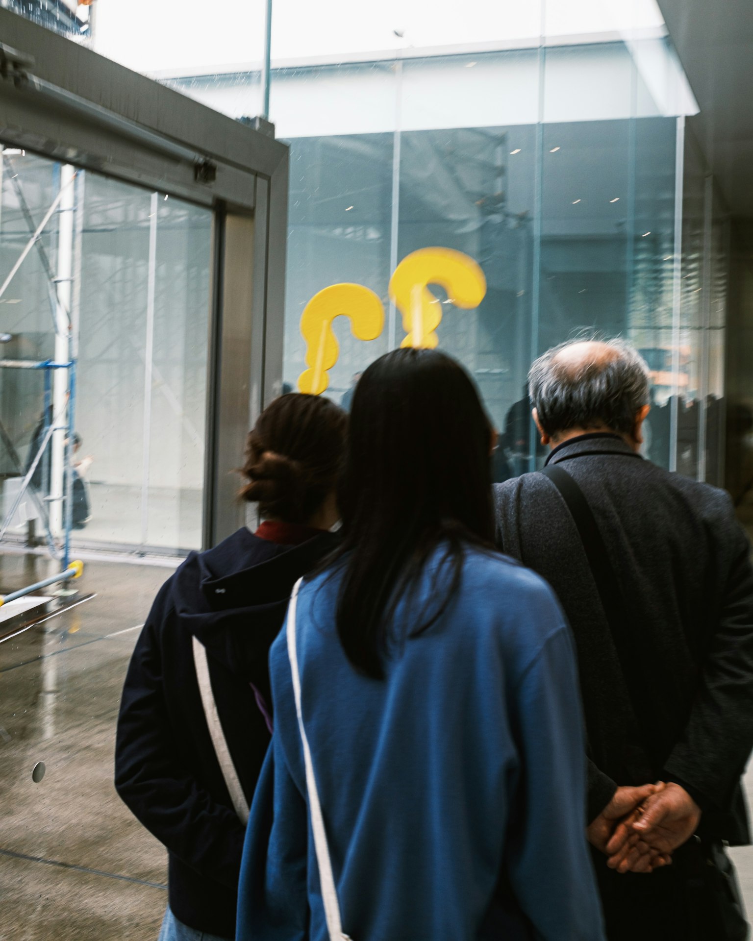 人々が黄色いアート作品を見つめるシーン