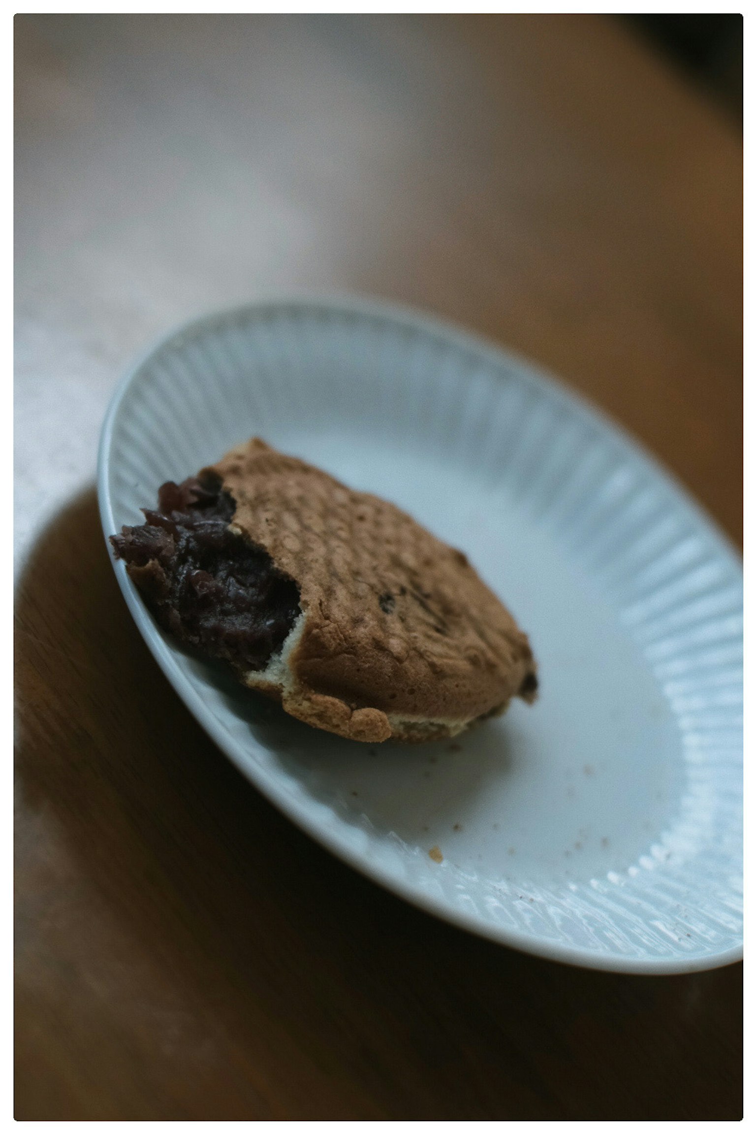 皿の上に置かれた一口かじられたスイーツの写真