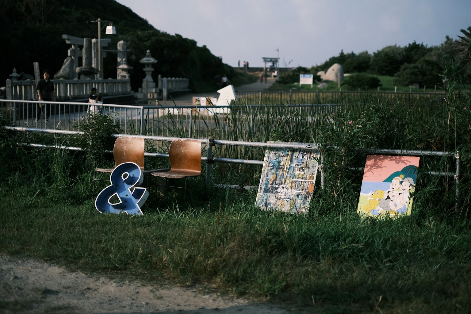 Paisaje con sillas y obras de arte en la hierba