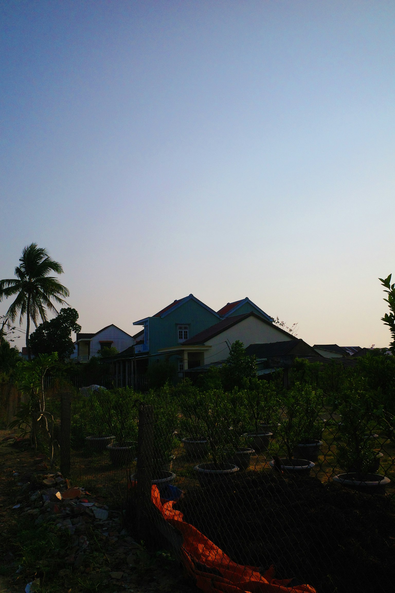 Houses and farmland under a blue sky