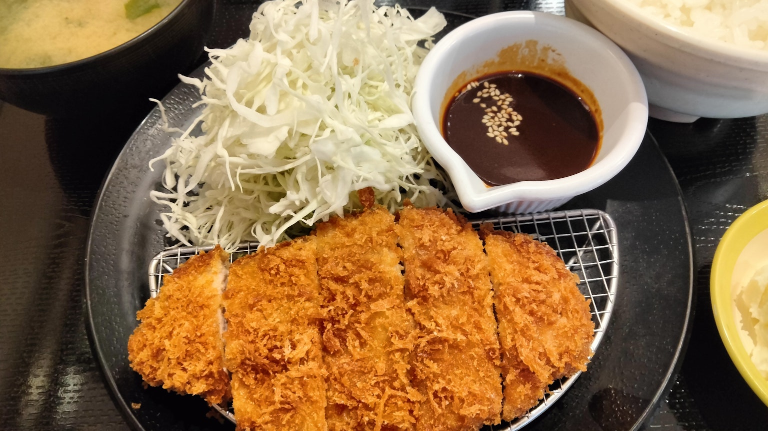 Teller mit frittiertem Tonkatsu, gehobeltem Kohl und Dip-Sauce