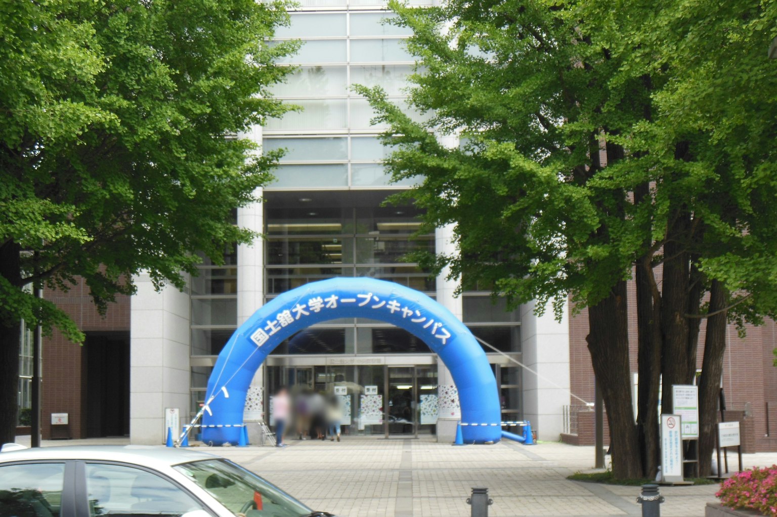 建筑入口处有蓝色拱门，周围被绿色树木环绕