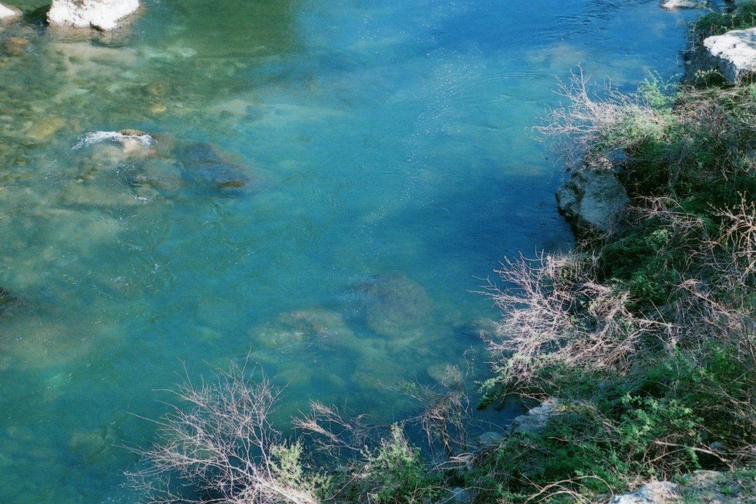 Un paysage de rivière serein avec de l'eau bleue claire et des rochers visibles