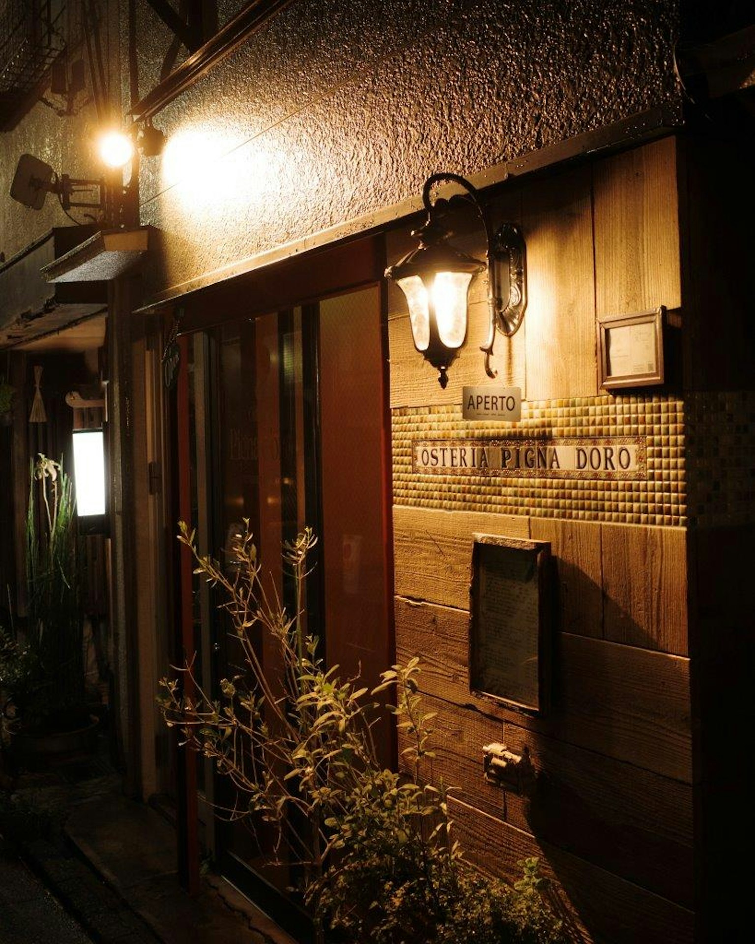 Entrata di un ristorante in legno in una strada buia illuminazione calda che crea un'atmosfera accogliente